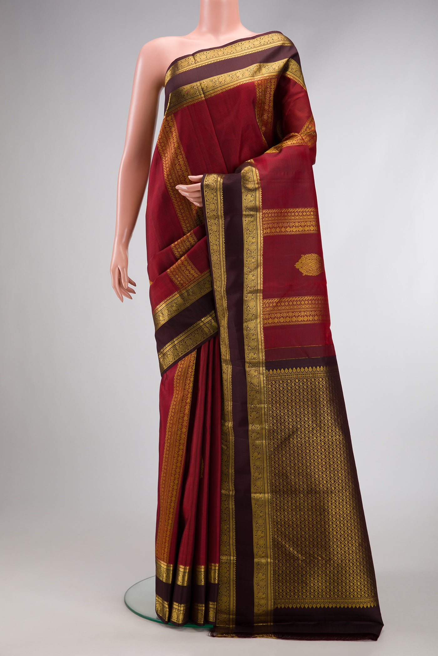 Maroon Kanchipuram Silk Saree with Stripes on the body and Zari Border.  displayed on a mannequin