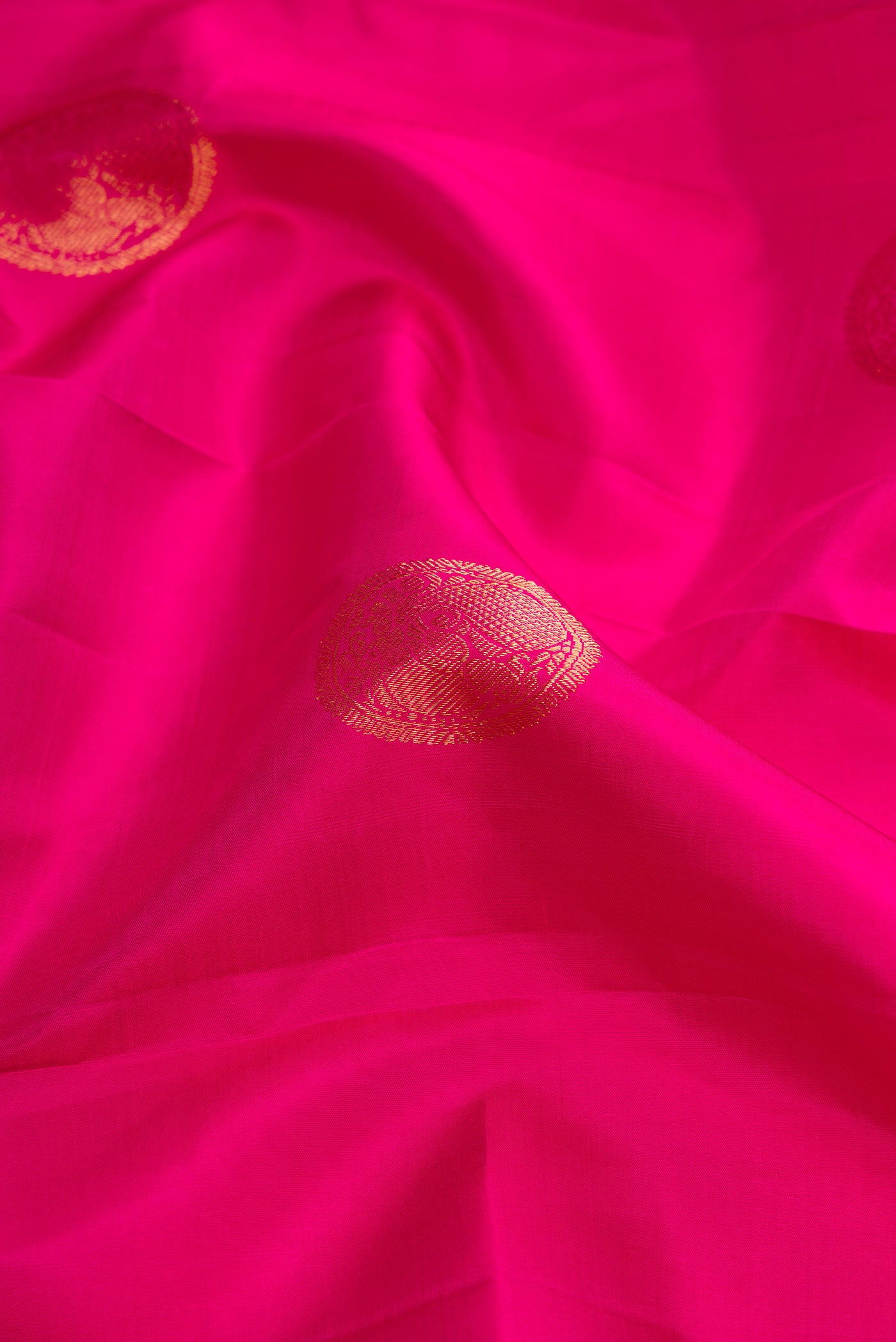 Close up of Dark Pink Dual Tone Kanjivaram Silk Saree with Zari Butta on the body and Zari Border.  displaying folds