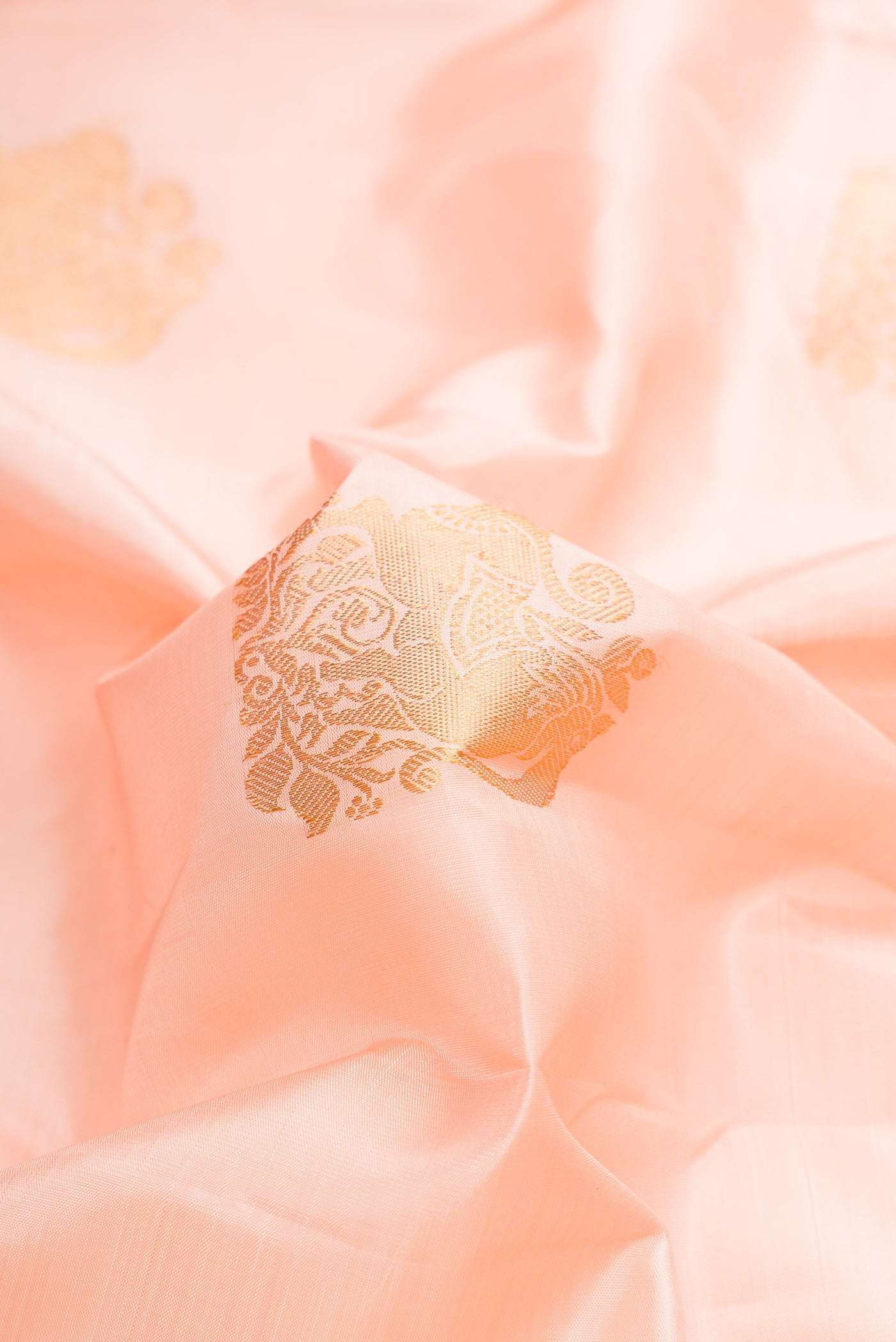 Close up of Pink Dual Tone Kanjivaram Silk Saree with Zari Butta on the body and Zari Border.  displaying folds