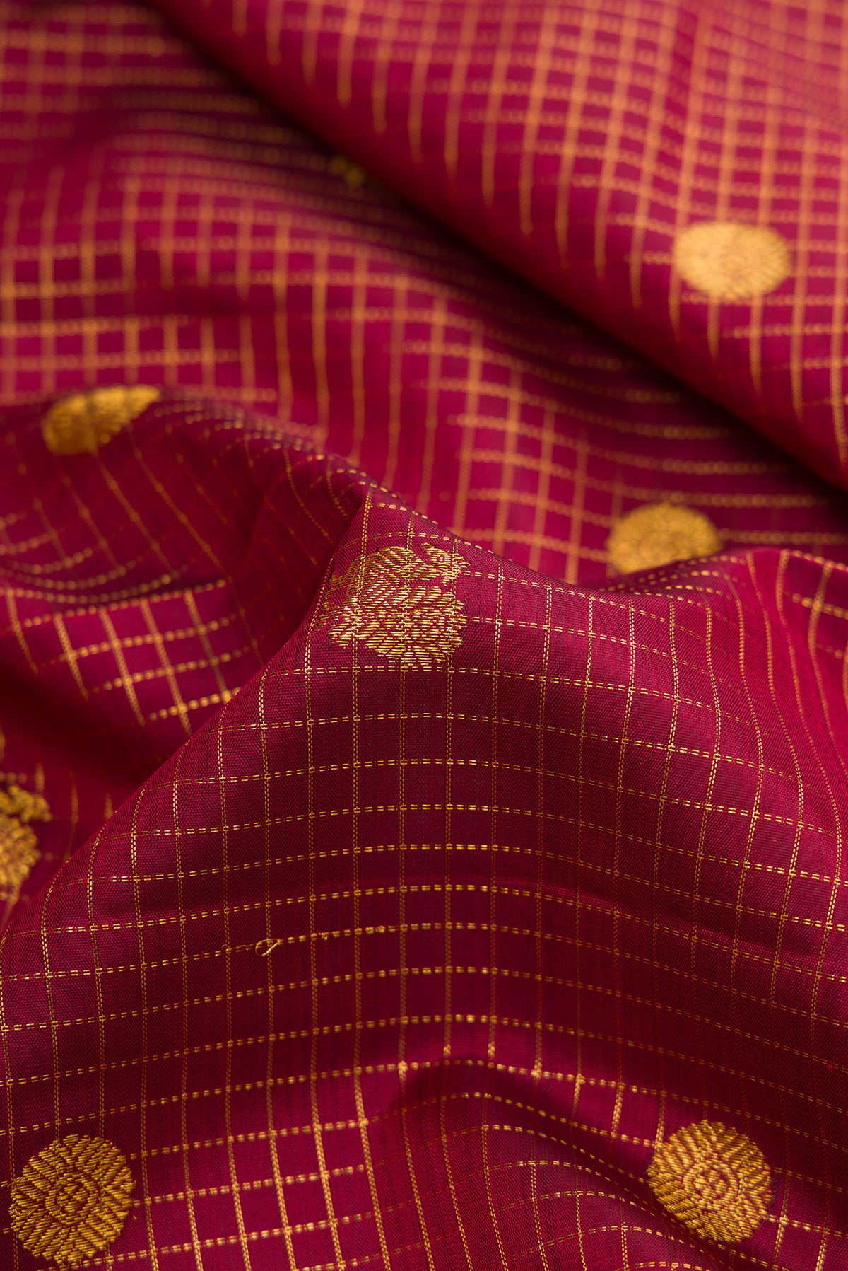 Close up of Maroon Dual Tone Kanjivaram Silk Saree with Checked design on the body and Zari Border.  displaying folds