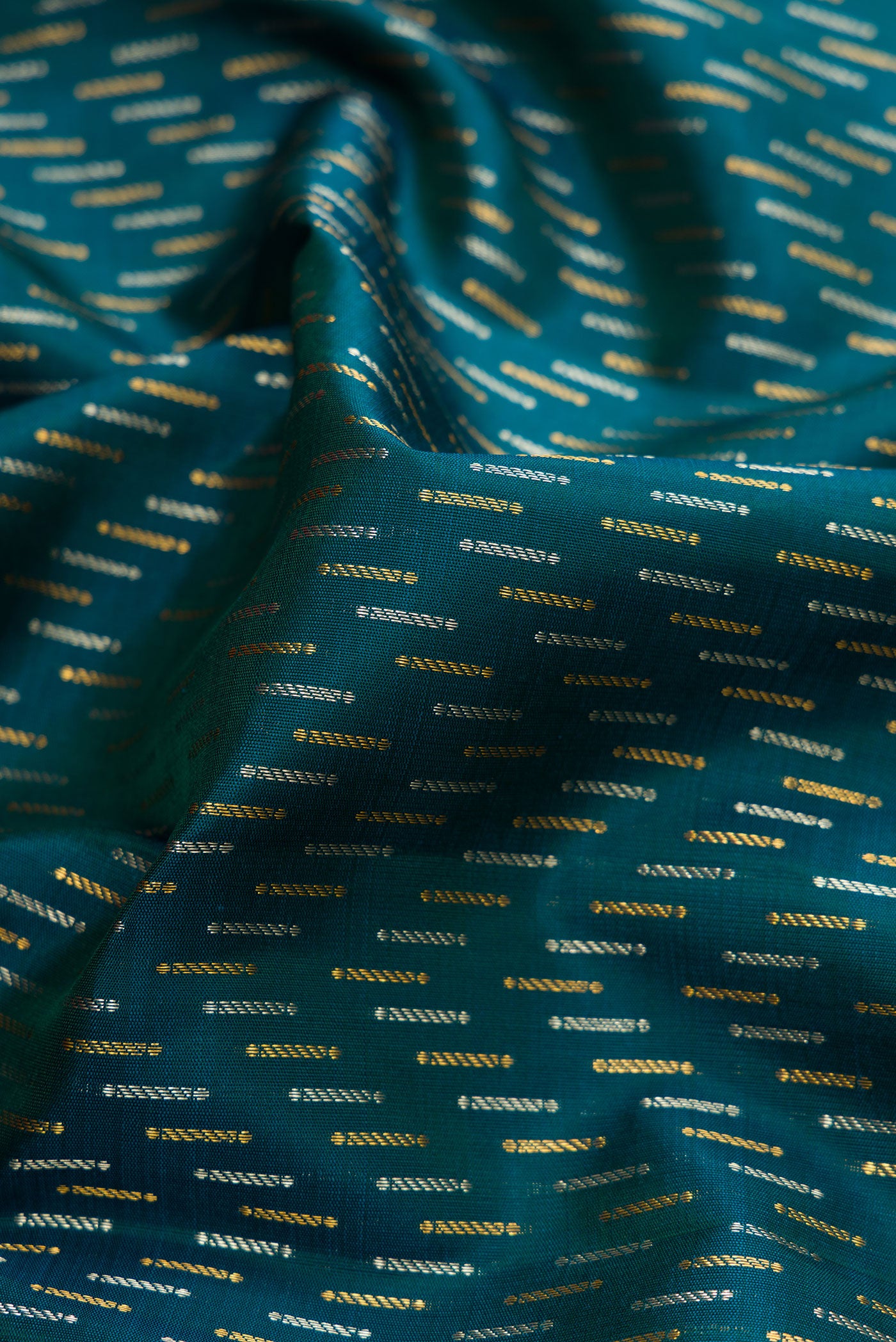 Close up of Green Dual Tone Kanjivaram Silk Saree with Zari Brocade on the body and Zari Border.  displaying folds