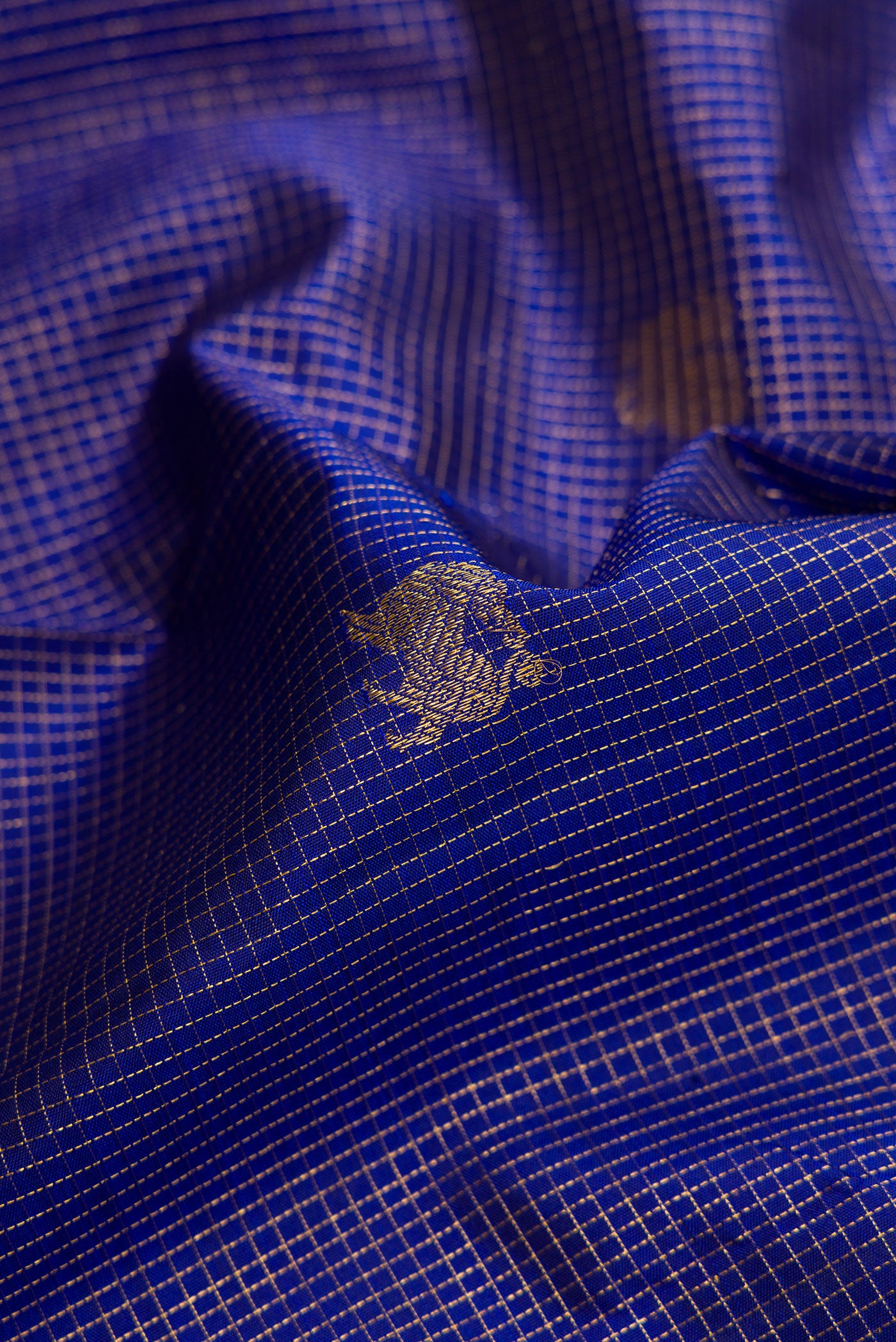 Close up of Navy Blue Dual Tone Kanjivaram Silk Saree with Checked design on the body and Zari Border.  displaying folds