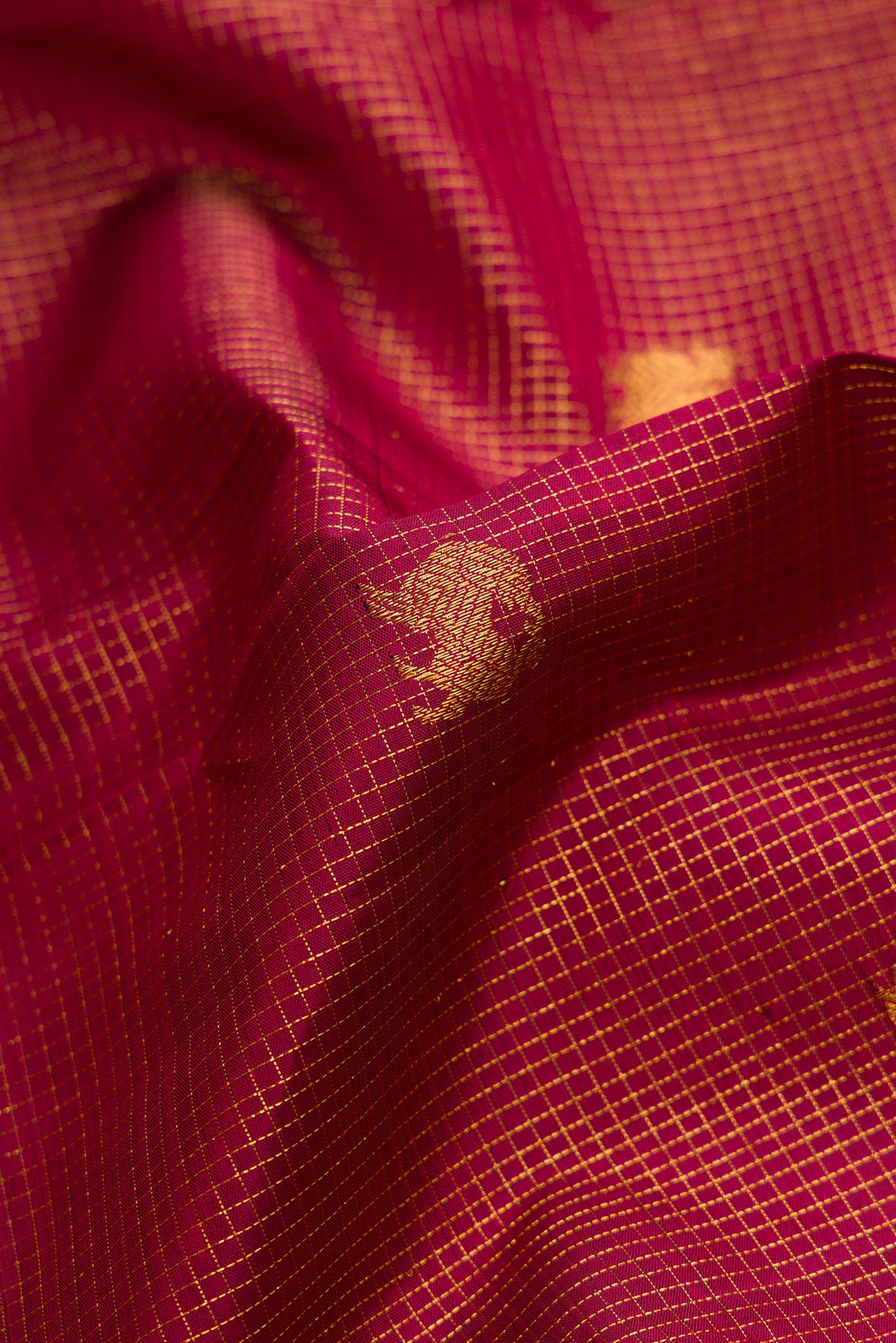 Close up of Maroon Kanjivaram Silk Saree with Zari Butta on the body and Zari Border.  displaying folds
