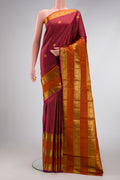 Maroon Kanjivaram Silk Saree with Zari Butta on the body and Zari Border.  displayed on a mannequin