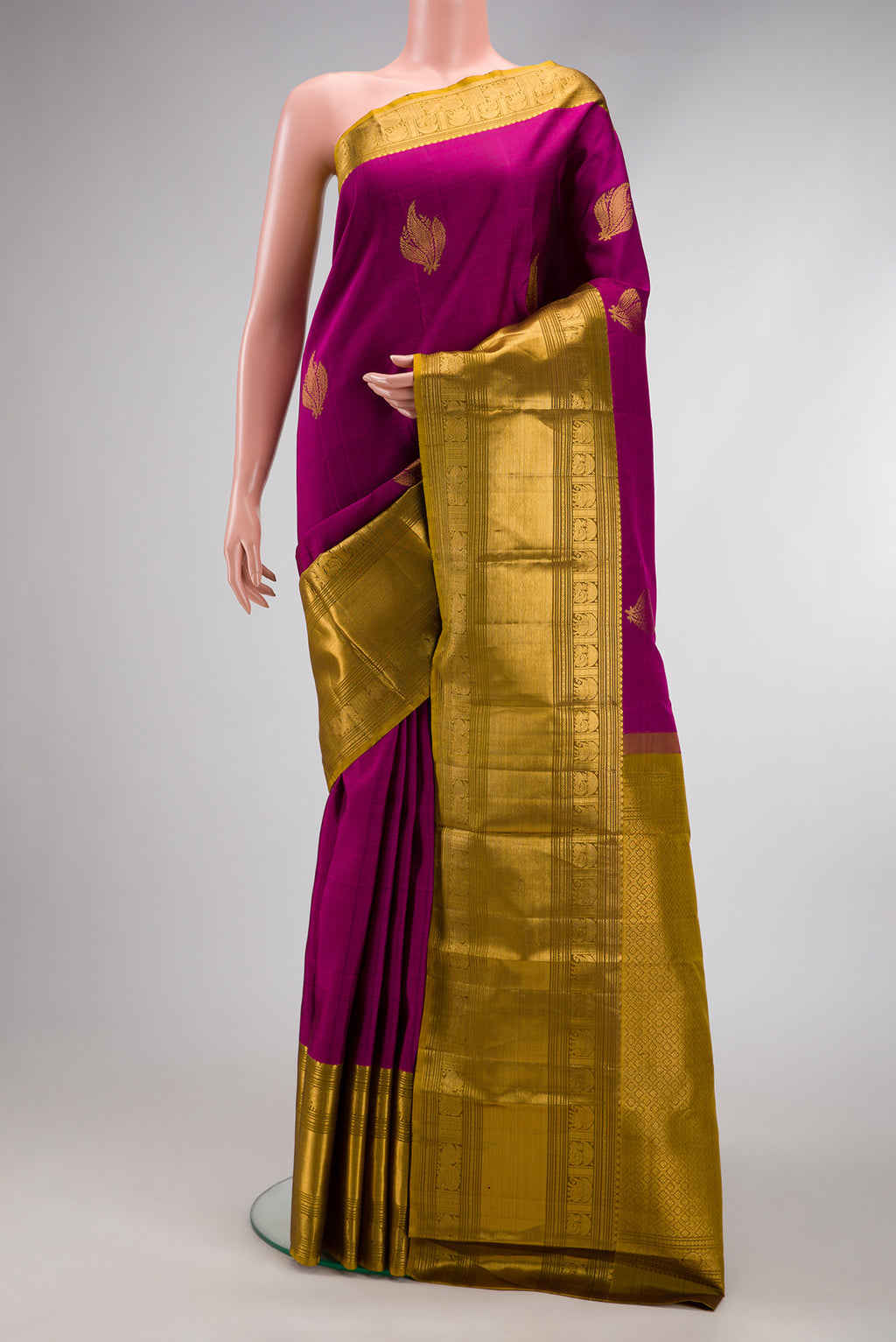 Magenta Kanchipuram Silk Saree with Zari Butta on the body and Zari Border.  displayed on a mannequin