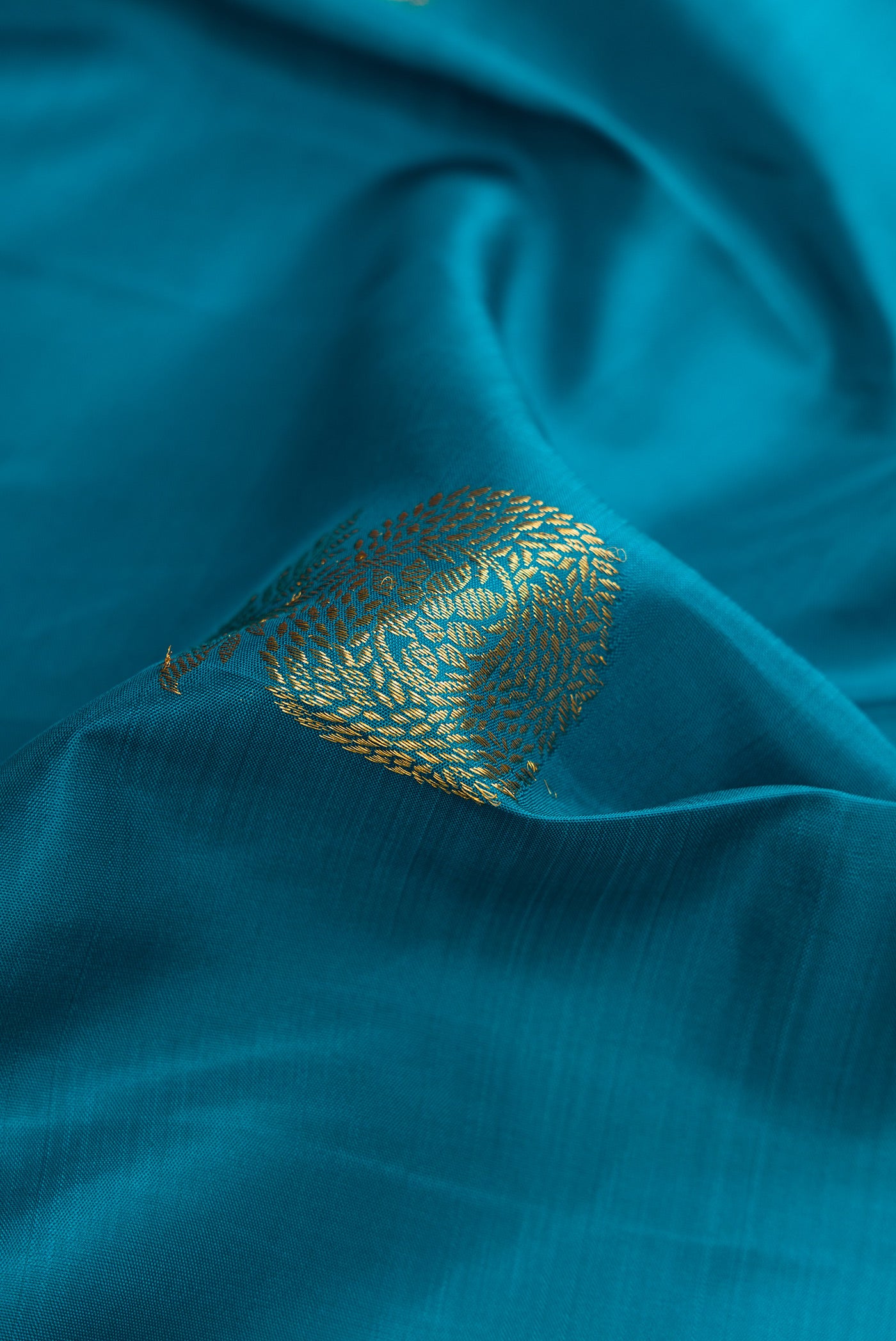 Close up of Maya Blue Dual Tone Kanchipuram Silk Saree with Zari Butta on the body and Zari Border.  displaying folds