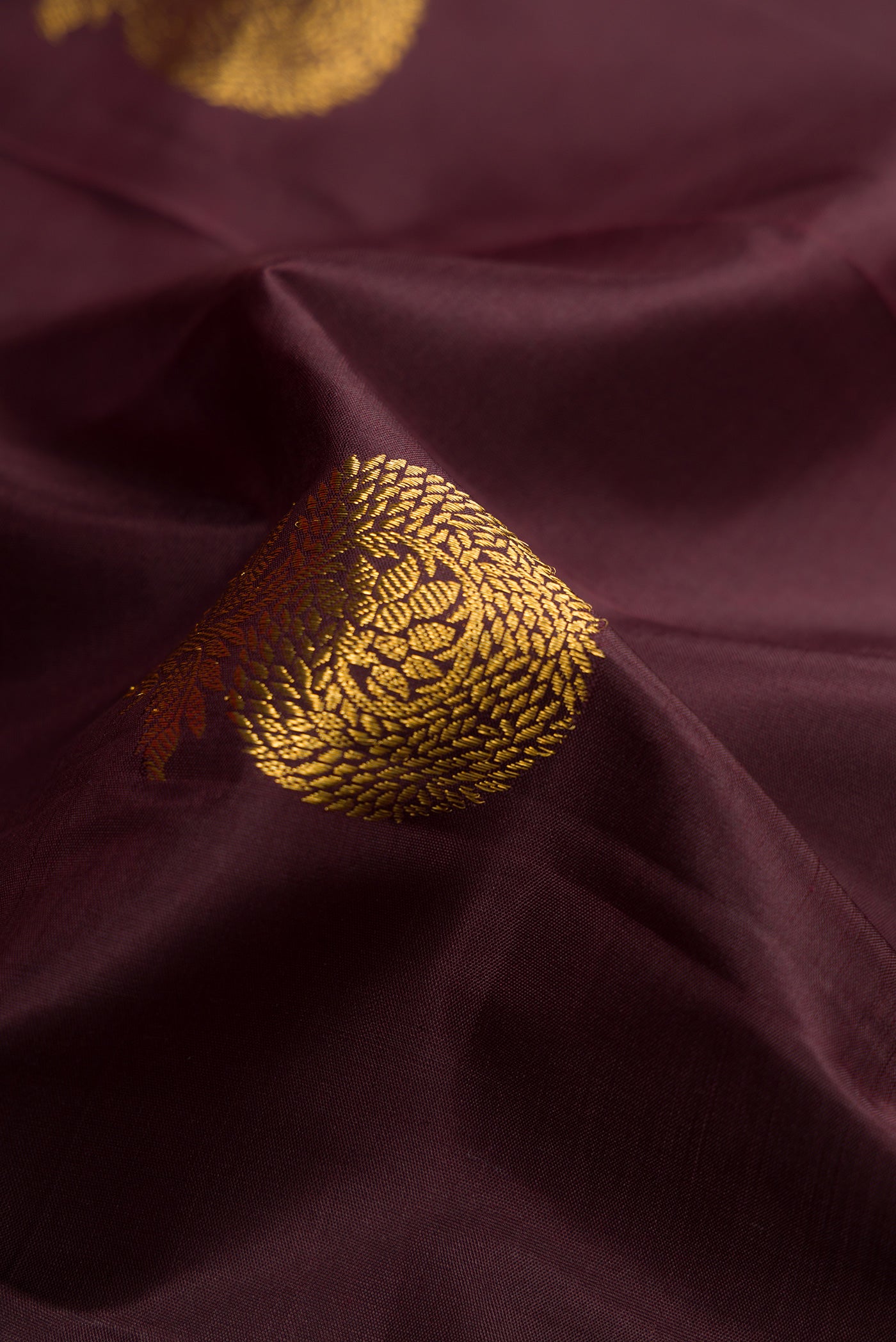 Close up of Brown Kanchipuram Silk Saree with Zari Butta on the body and Zari Border.  displaying folds