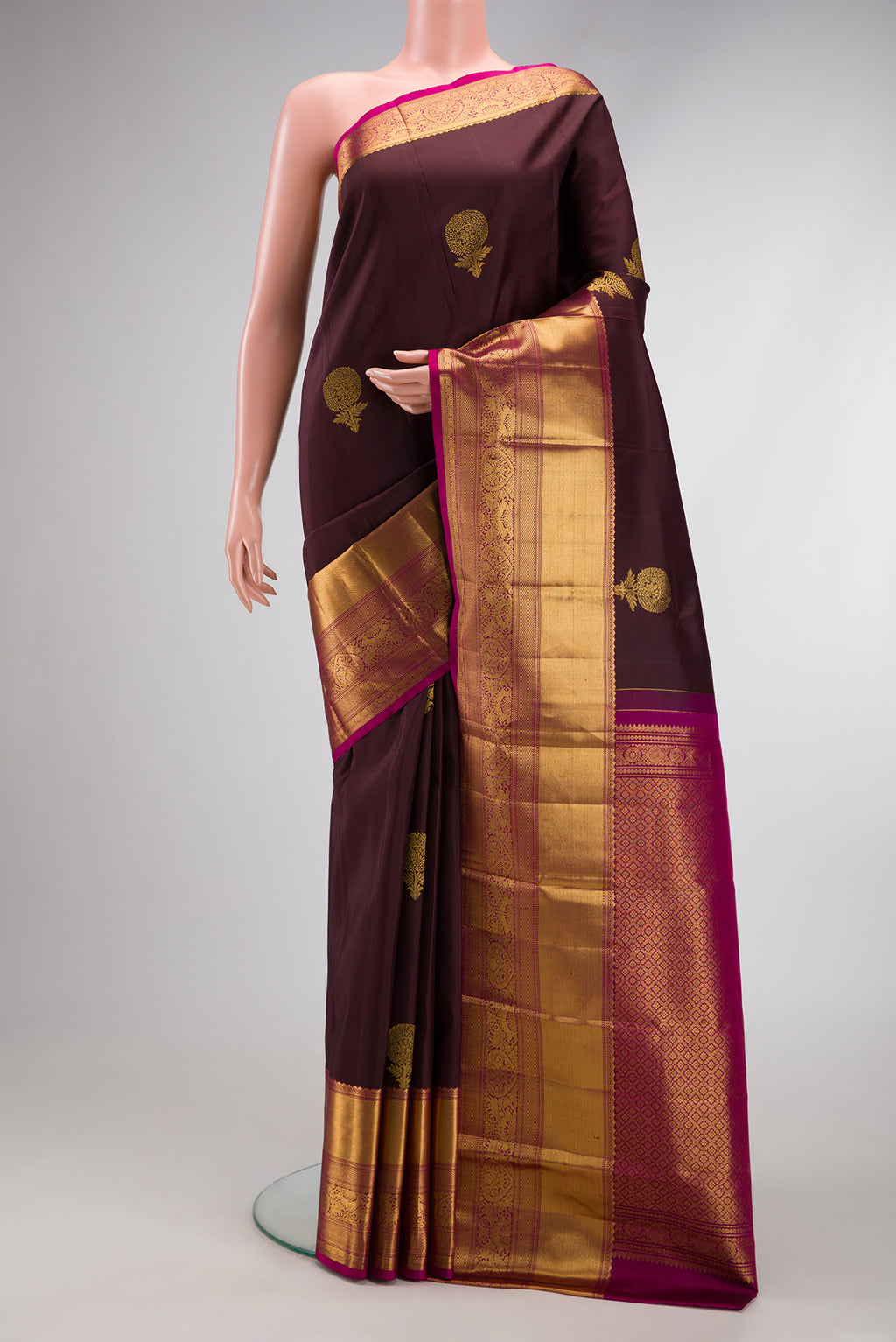 Brown Kanchipuram Silk Saree with Zari Butta on the body and Zari Border.  displayed on a mannequin