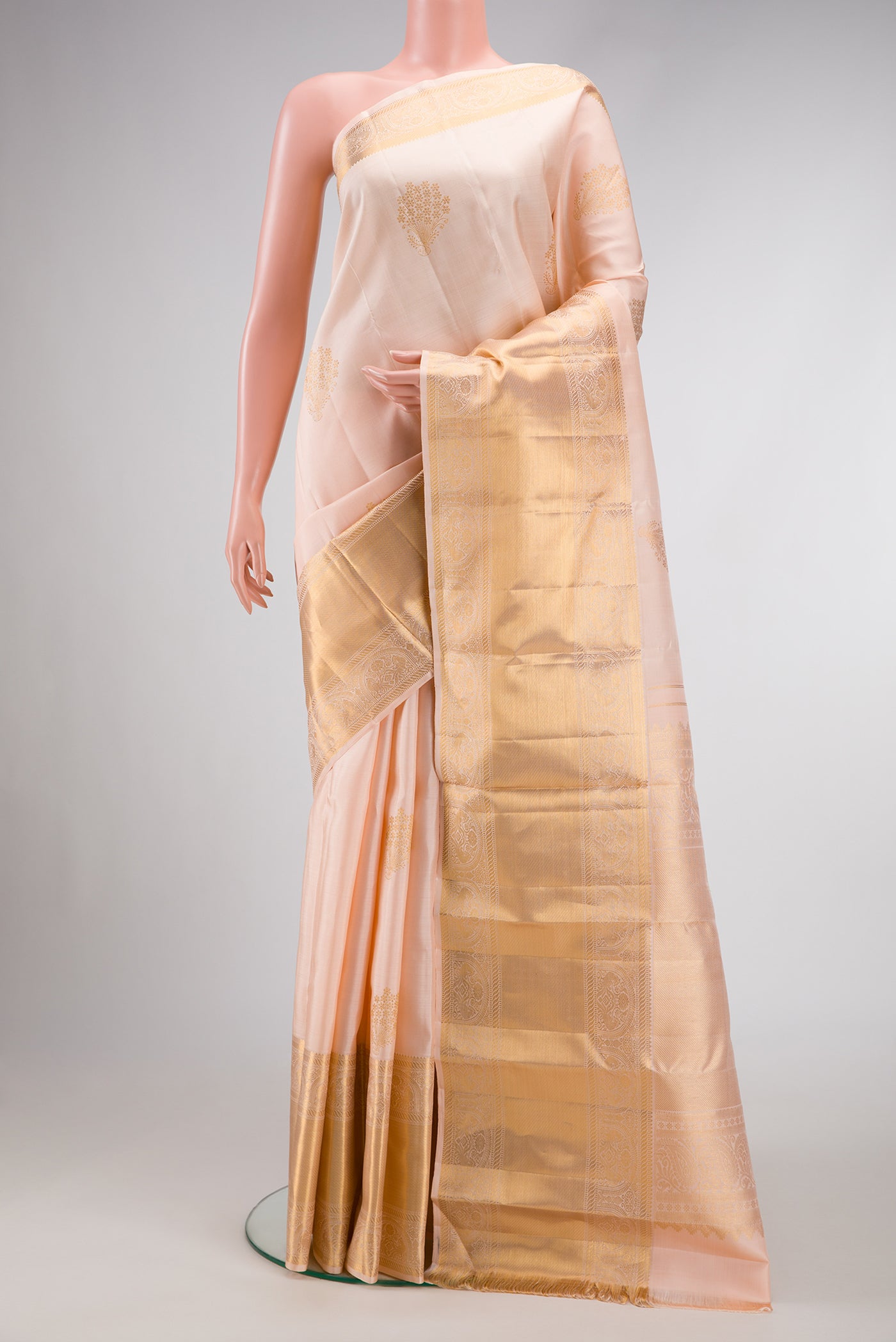 Peach Dual Tone Kanchipuram Silk Saree with Zari Butta on the body and Zari Border.  displayed on a mannequin