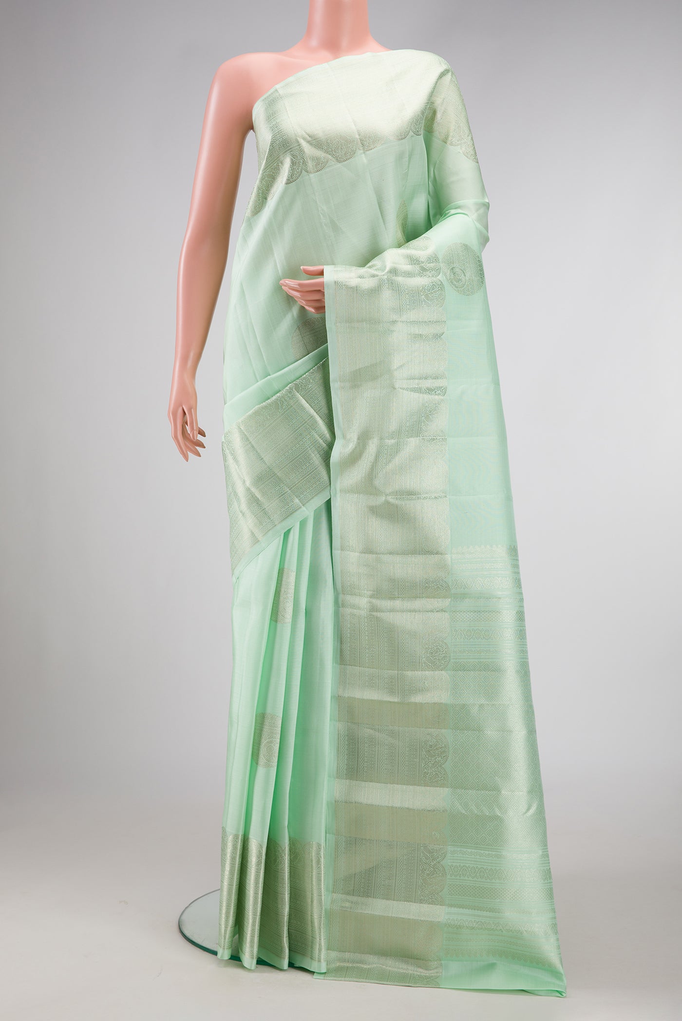 Pista Green Dual Tone Kanchipuram Silk Saree with Zari Butta on the body and Zari Border.  displayed on a mannequin