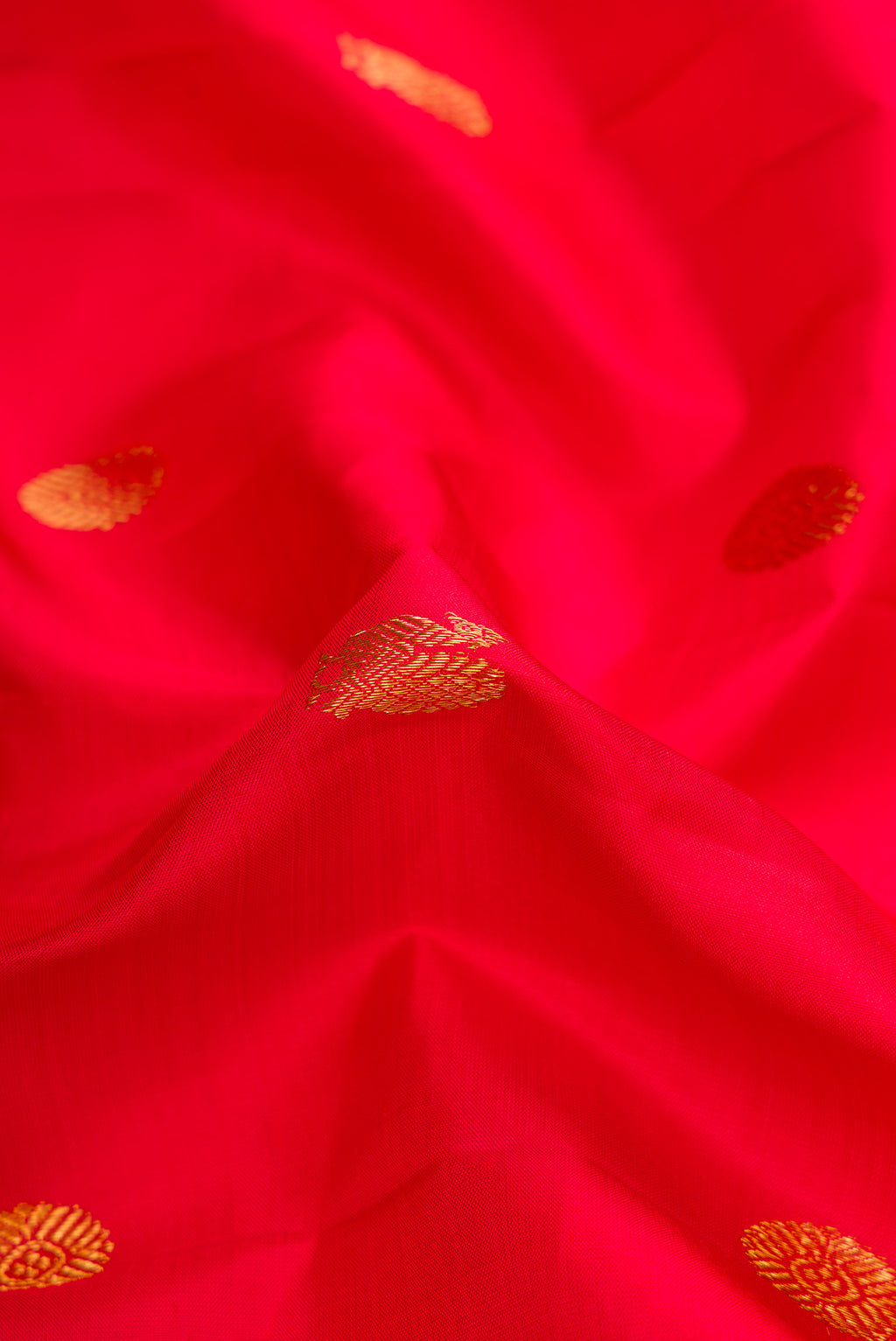 Close up of Red Dual Tone Kanchipuram Silk Saree with Zari Butta on the body and Zari Border.  displaying folds