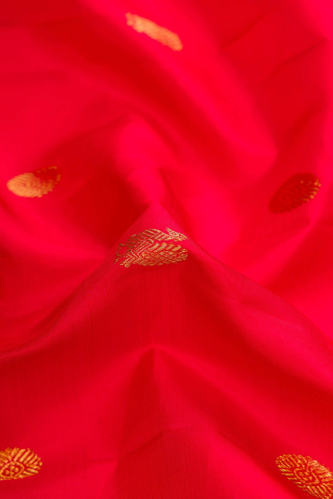 Close up of Red Dual Tone Kanchipuram Silk Saree with Zari Butta on the body and Zari Border.  displaying folds