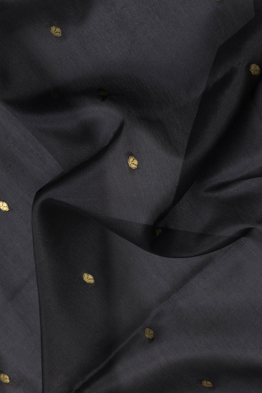 Close up of Black Dual Tone Mysore Silk Saree with Zari Butta on the body and Zari Border.  displaying folds