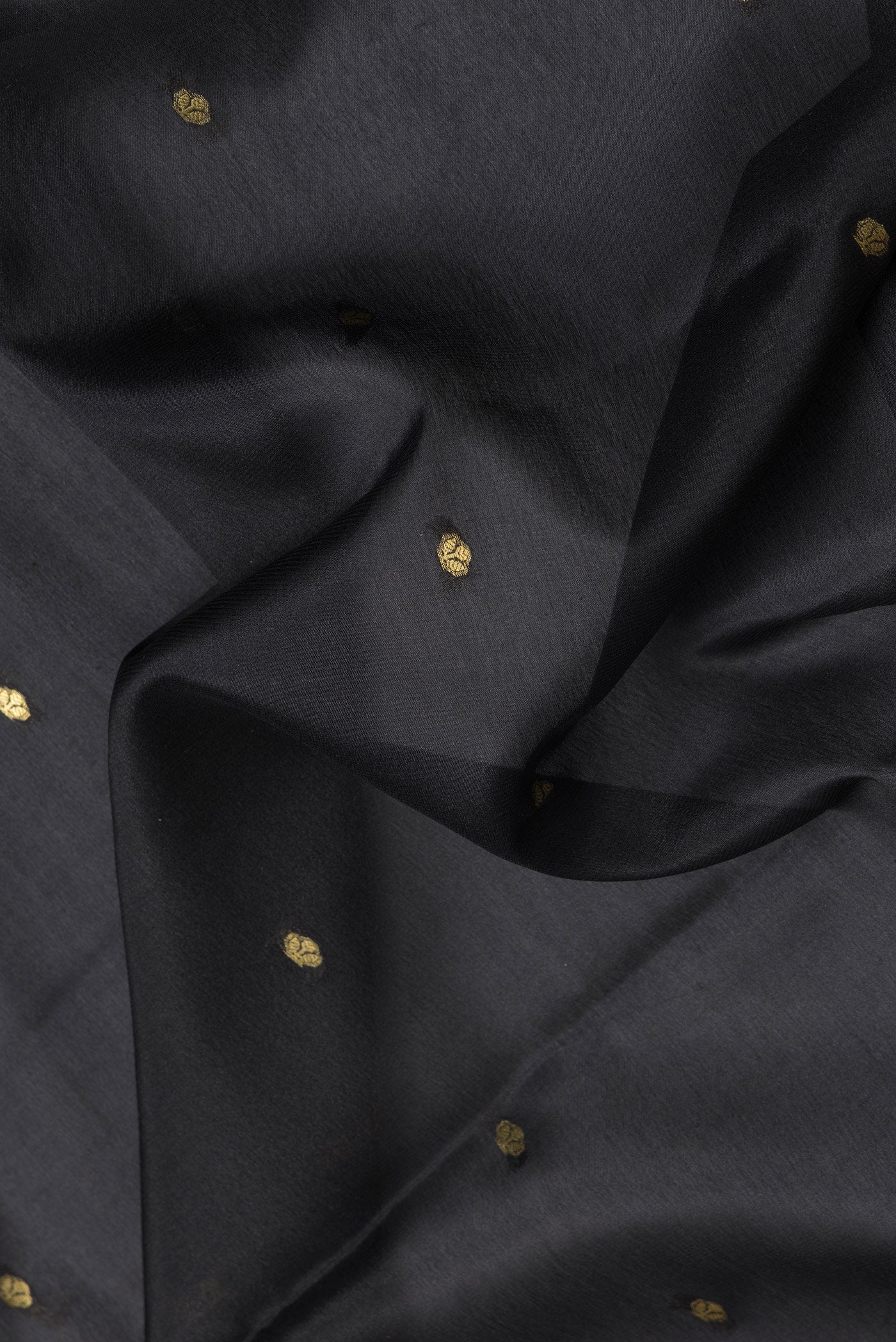 Close up of Black Dual Tone Mysore Silk Saree with Zari Butta on the body and Zari Border.  displaying folds