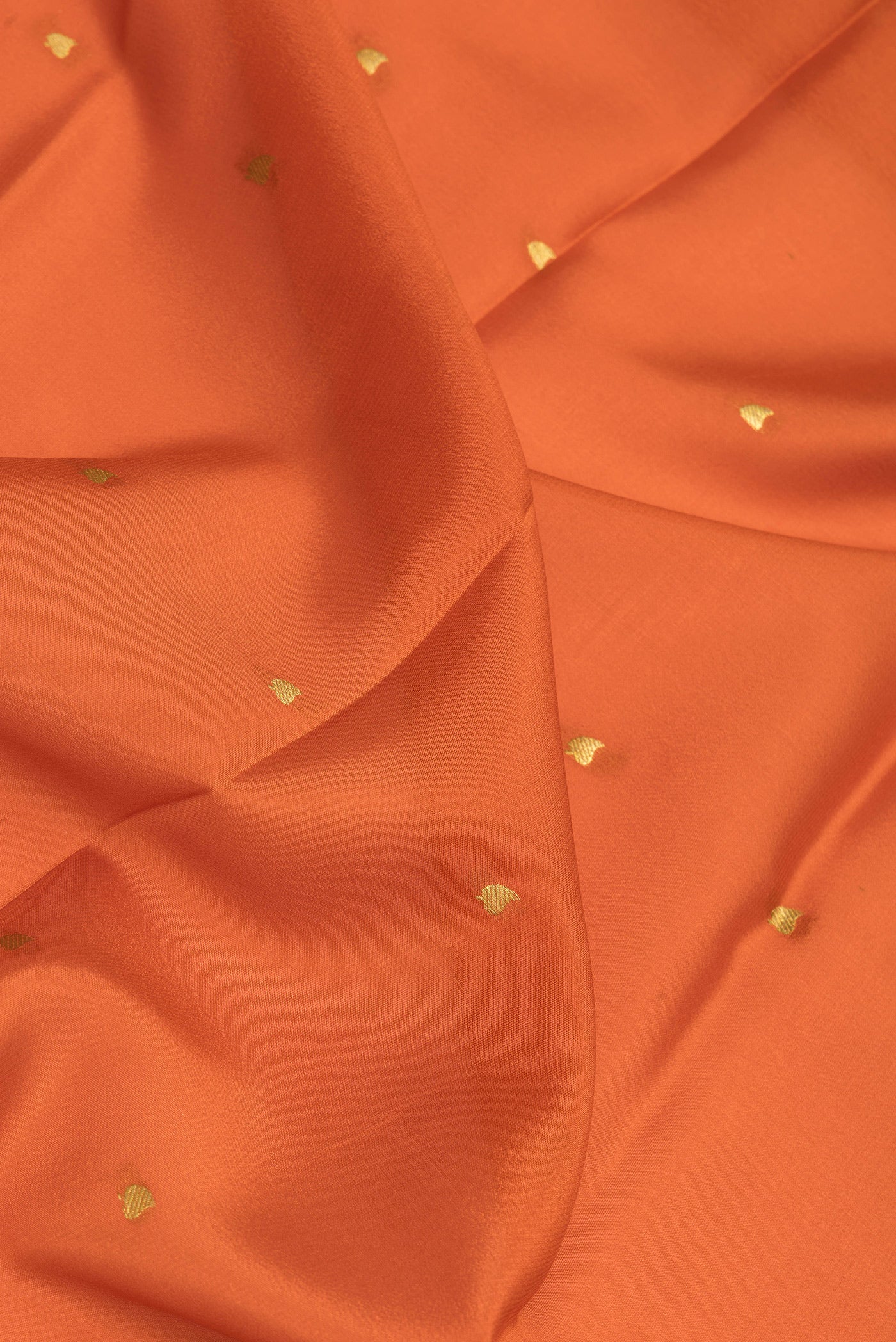 Close up of Orange Mysore Silk Saree with Zari Butta on the body and Zari Border.  displaying folds