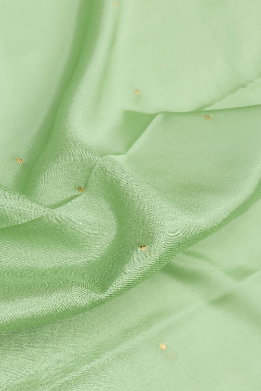 Close up of Pista Green Mysore Silk Saree with Zari Butta on the body and Zari Border.  displaying folds