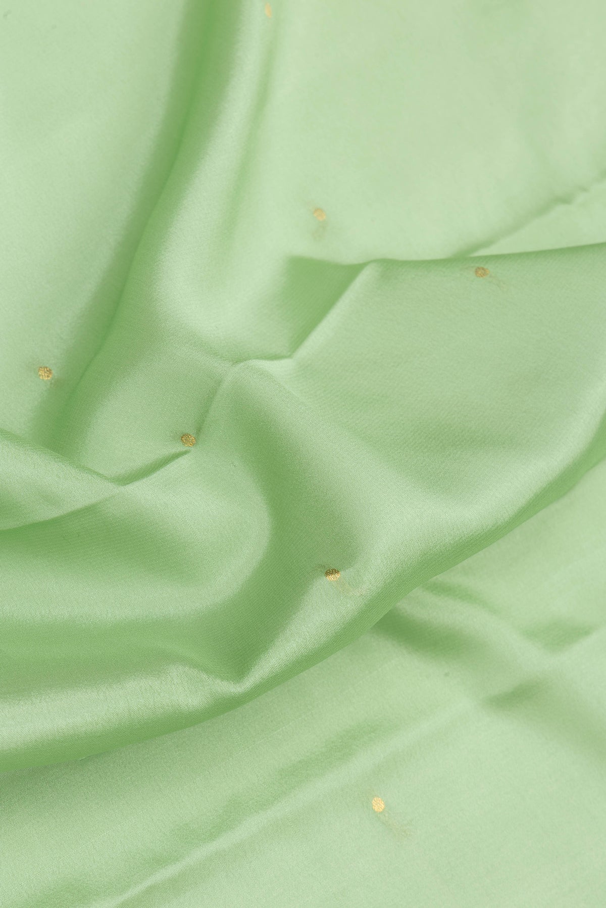 Close up of Pista Green Mysore Silk Saree with Zari Butta on the body and Zari Border.  displaying folds