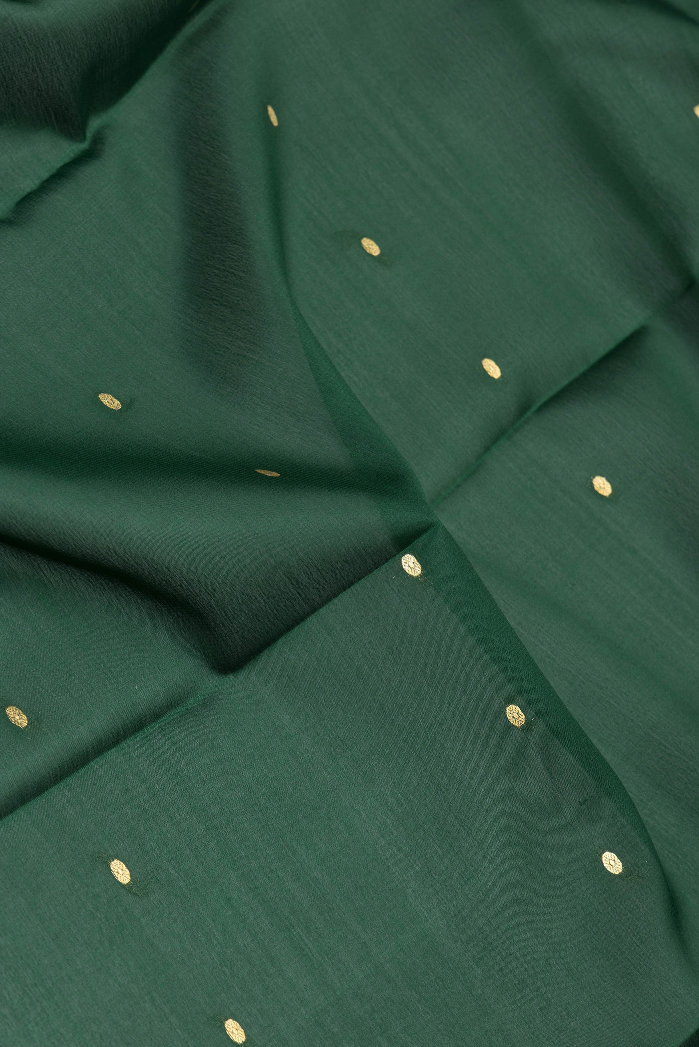 Close up of Bottle Green Mysore Silk Saree with Zari Butta on the body and Zari Border.  displaying folds