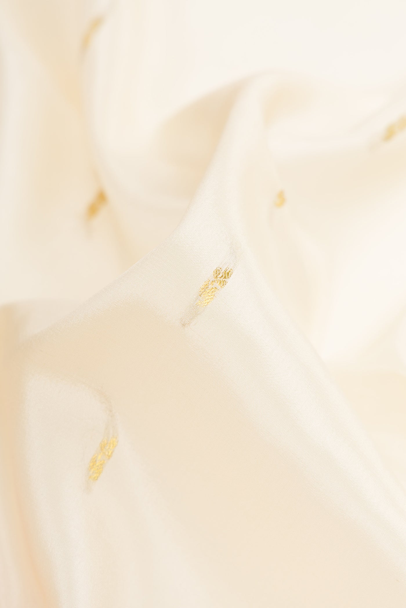Close up of Cream Mysore Crepe Saree with Zari Butta on the body and Zari Border.  displaying folds
