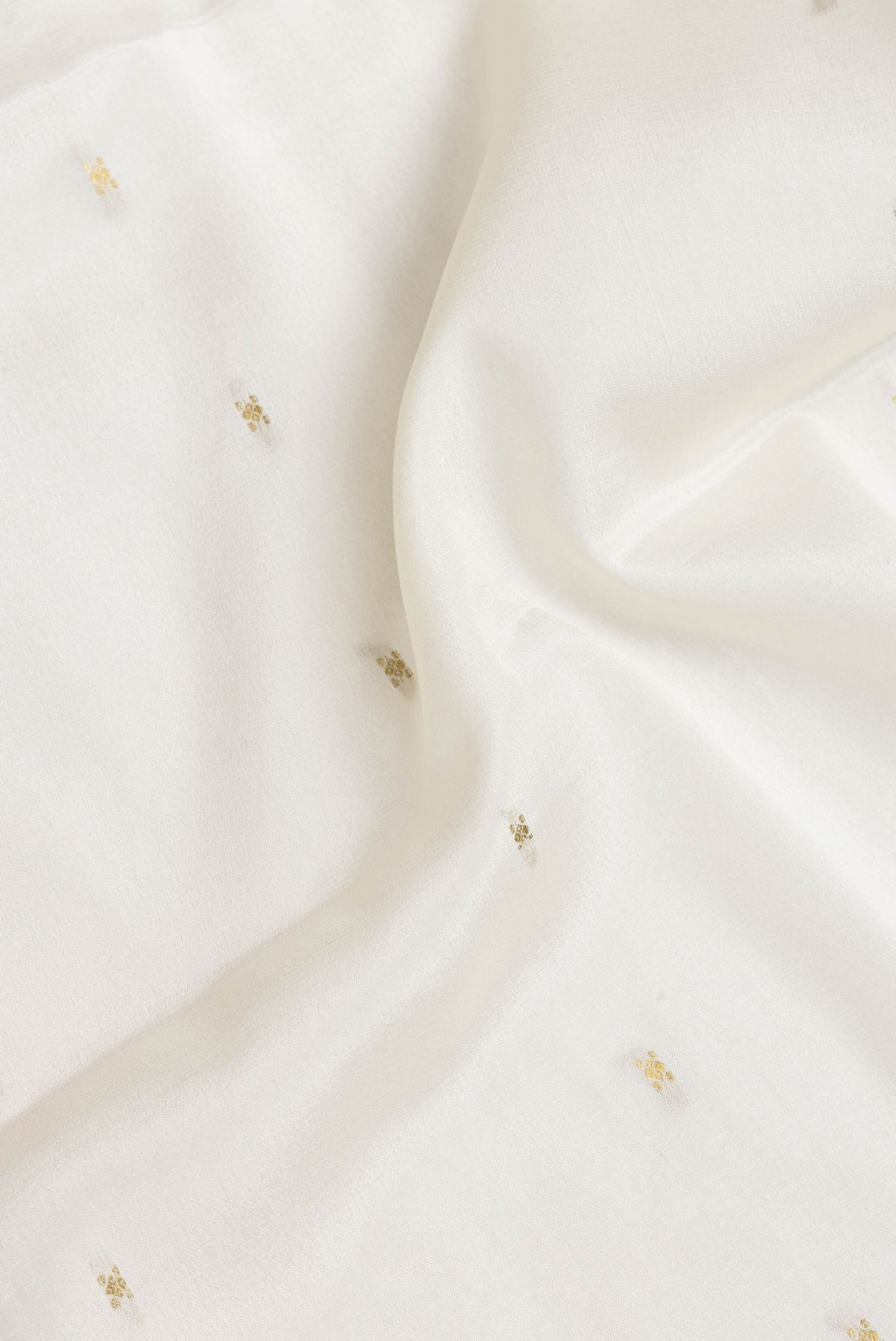 Close up of Off White Dual Tone Mysore Silk Saree with Zari Butta on the body and Zari Border.  displaying folds