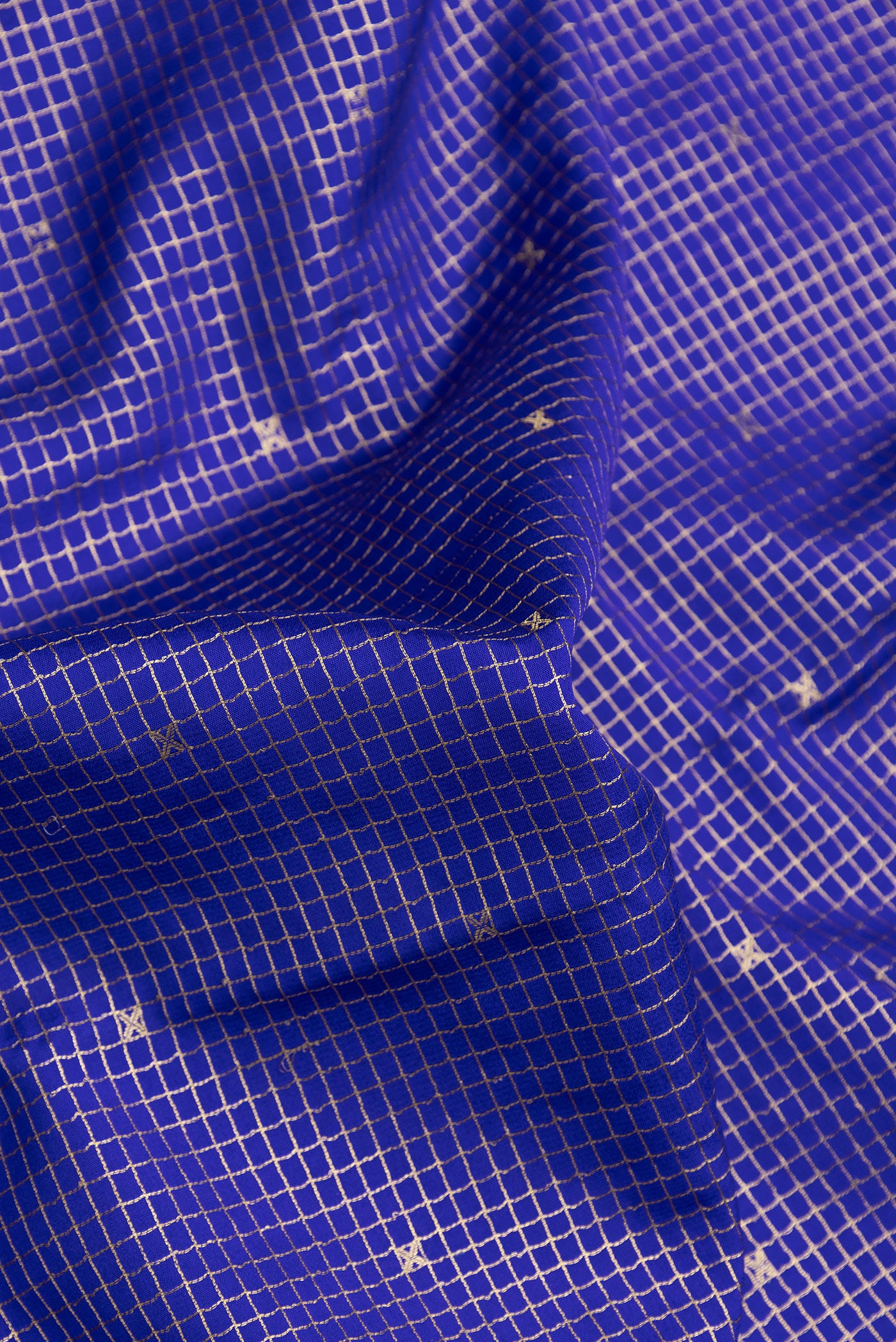 Close up of Royal Blue Dual Tone Mysore Silk Saree with Checked design on the body and Zari Border.  displaying folds