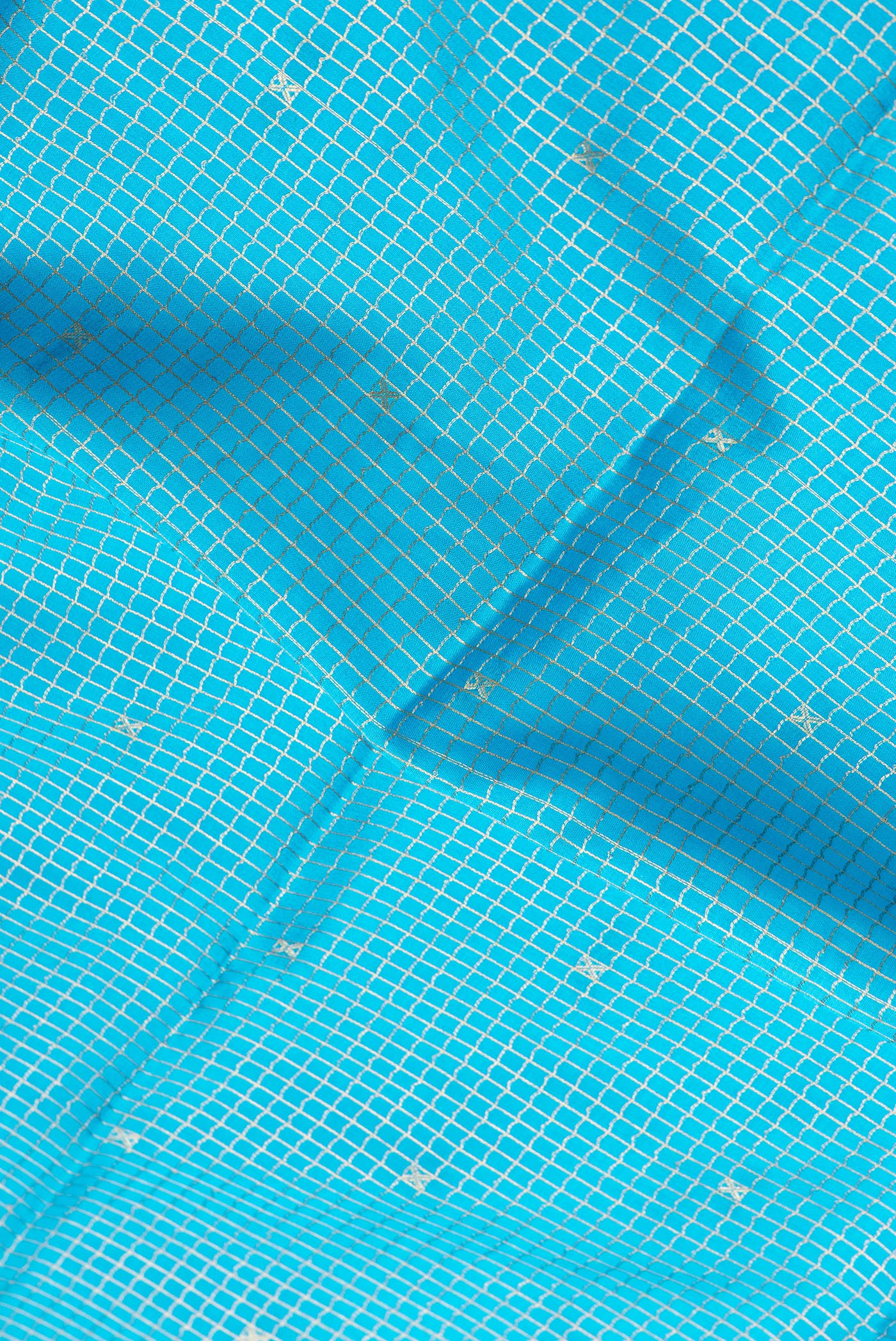 Close up of Sky Blue Dual Tone Mysore Silk Saree with Checked design on the body and Zari Border.  displaying folds