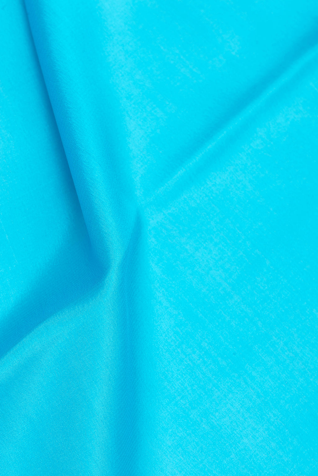Close up of Sky Blue Mysore Silk Saree with Plain Body and Zari Border.  displaying folds