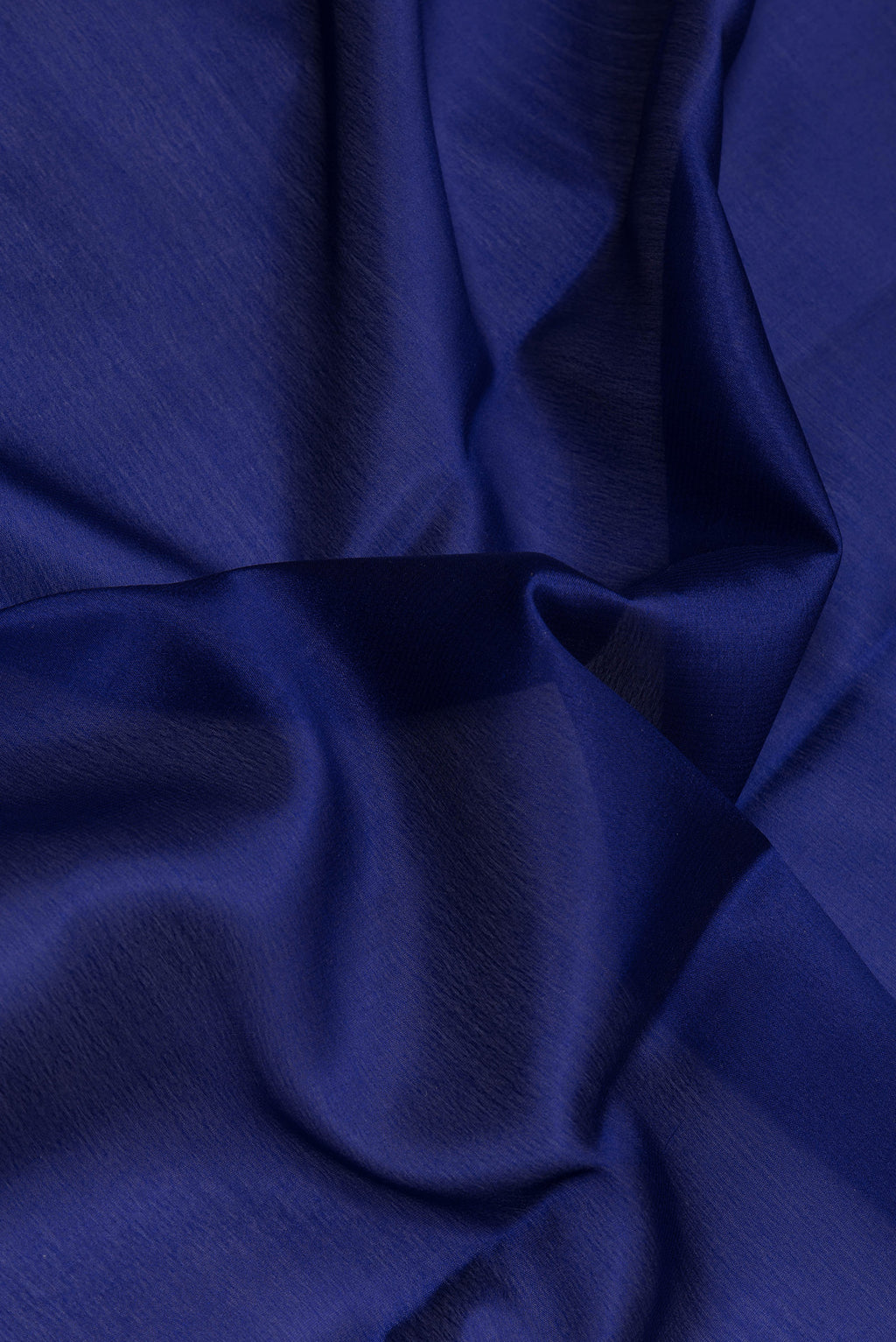 Close up of Navy Blue Mysore Crepe Saree with Plain Body and Zari Border.  displaying folds