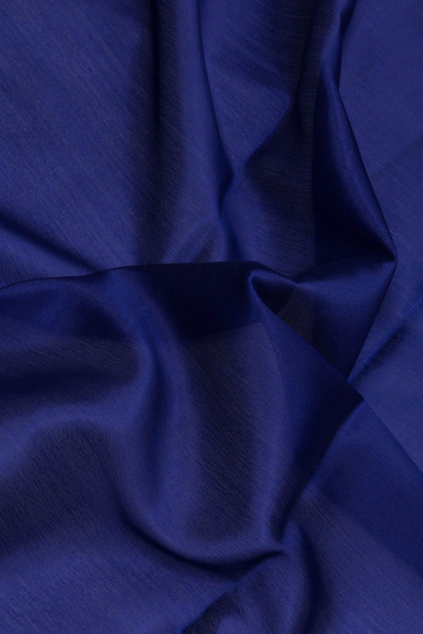 Close up of Navy Blue Mysore Crepe Saree with Plain Body and Zari Border.  displaying folds