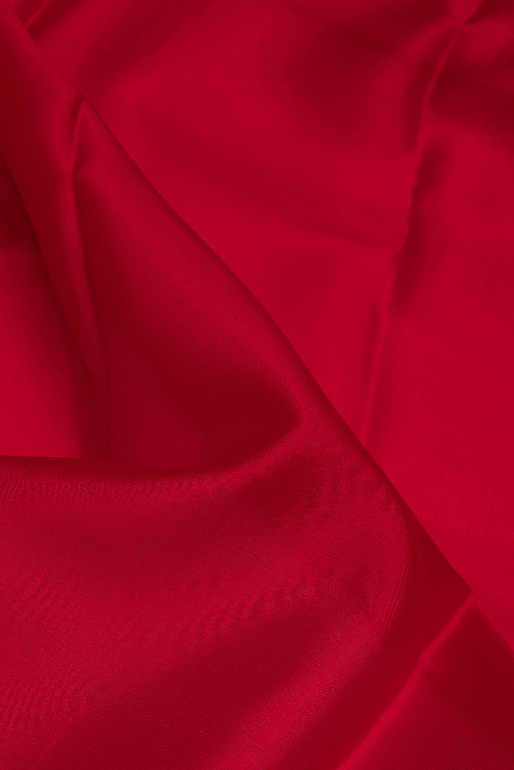 Close up of Red Mysore Crepe Saree with Plain Body and Zari Border.  displaying folds