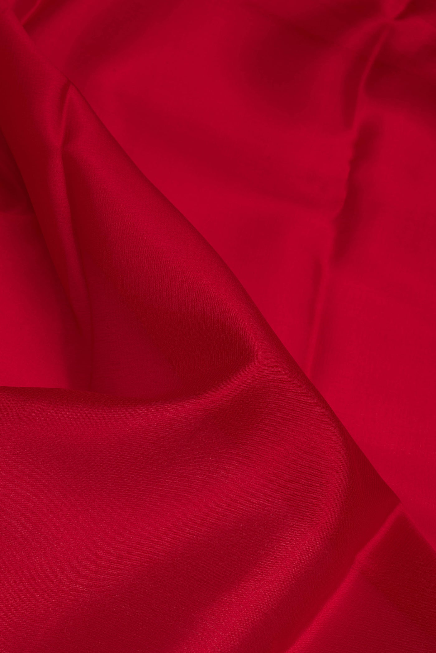 Close up of Red Mysore Crepe Saree with Plain Body and Zari Border.  displaying folds