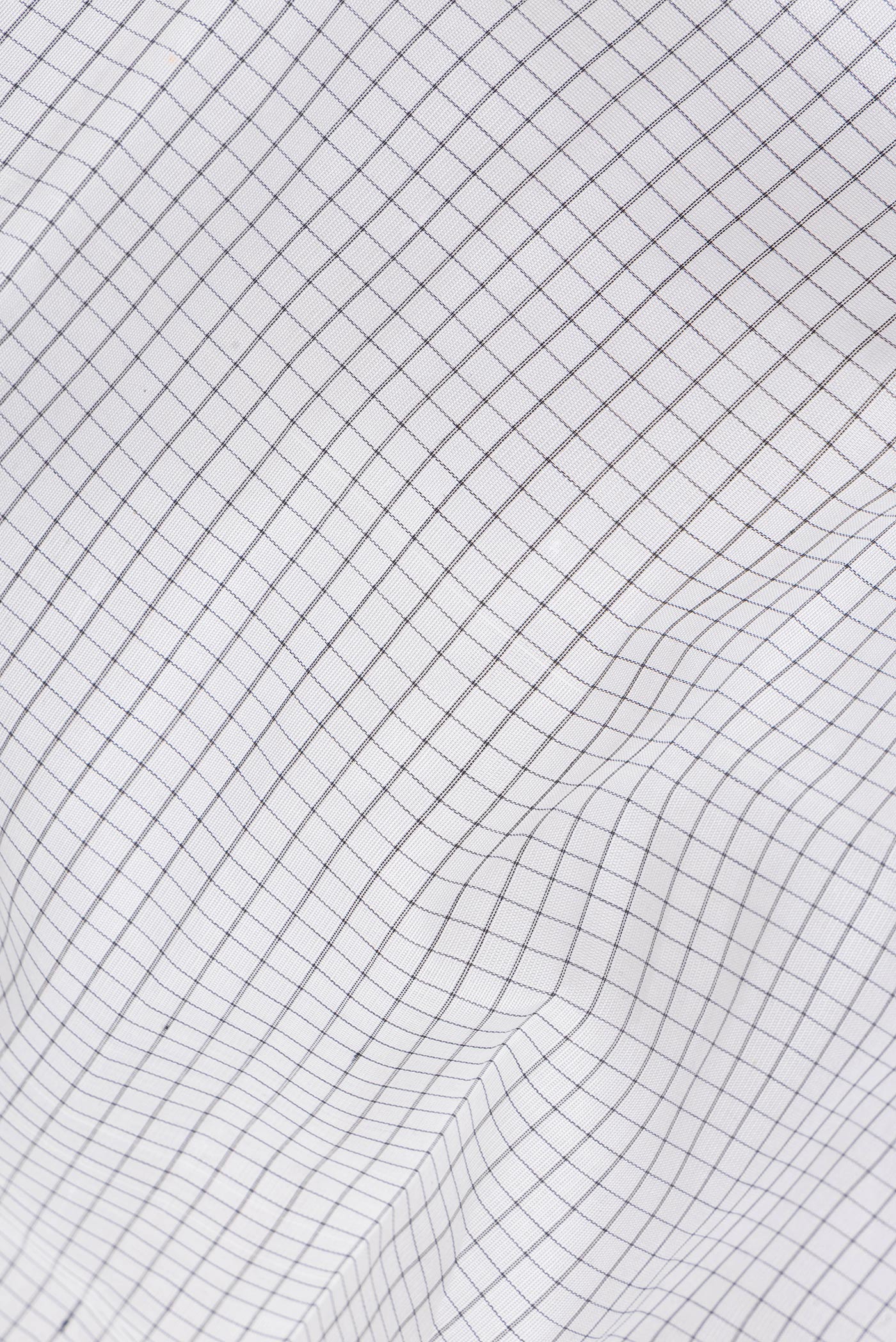 Close up of White Kanchi Cotton Saree with Checked design on the body and Temple Border.  displaying folds