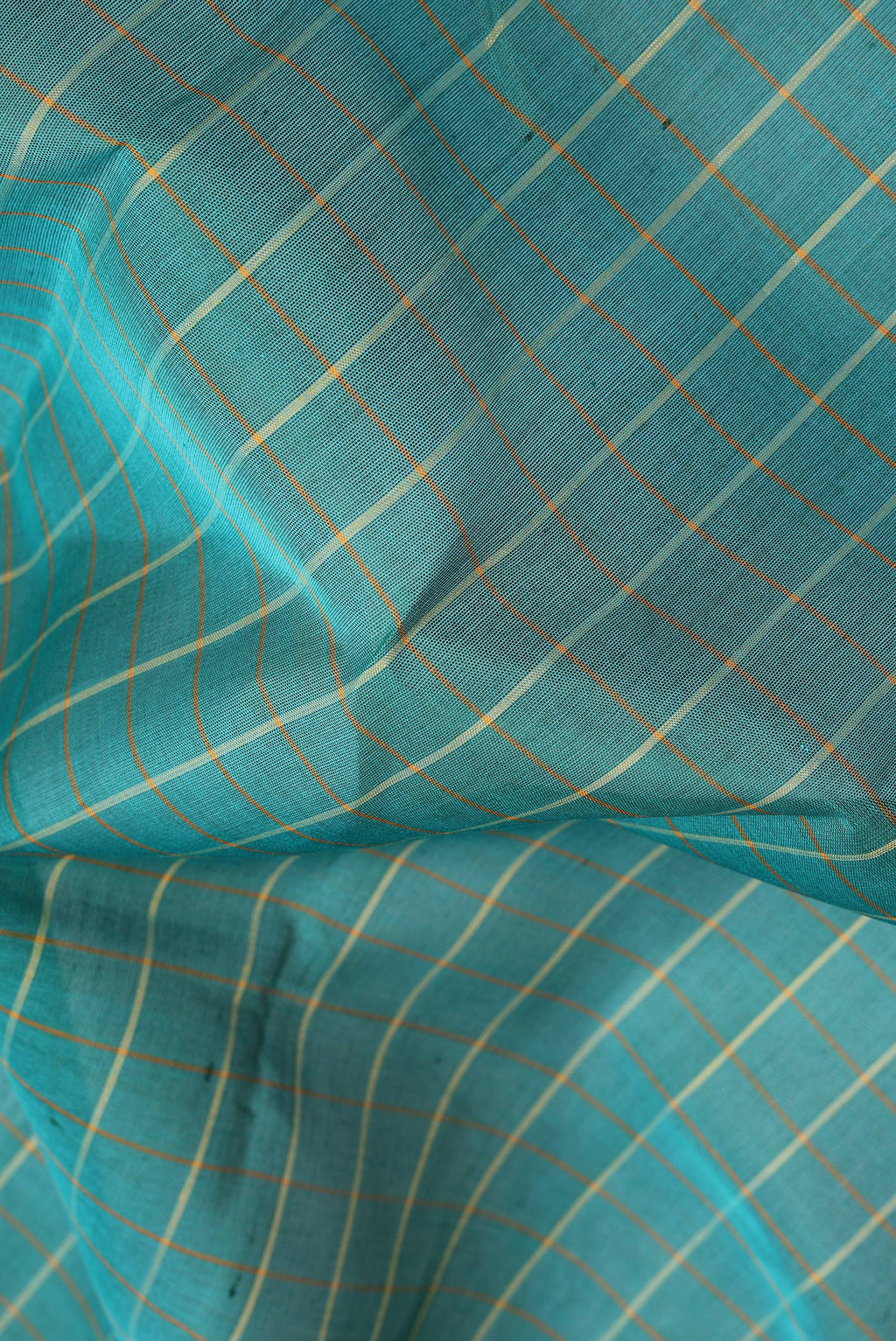 Close up of Green Kanchi Cotton Saree with Checked design on the body and Plain Border.  displaying folds