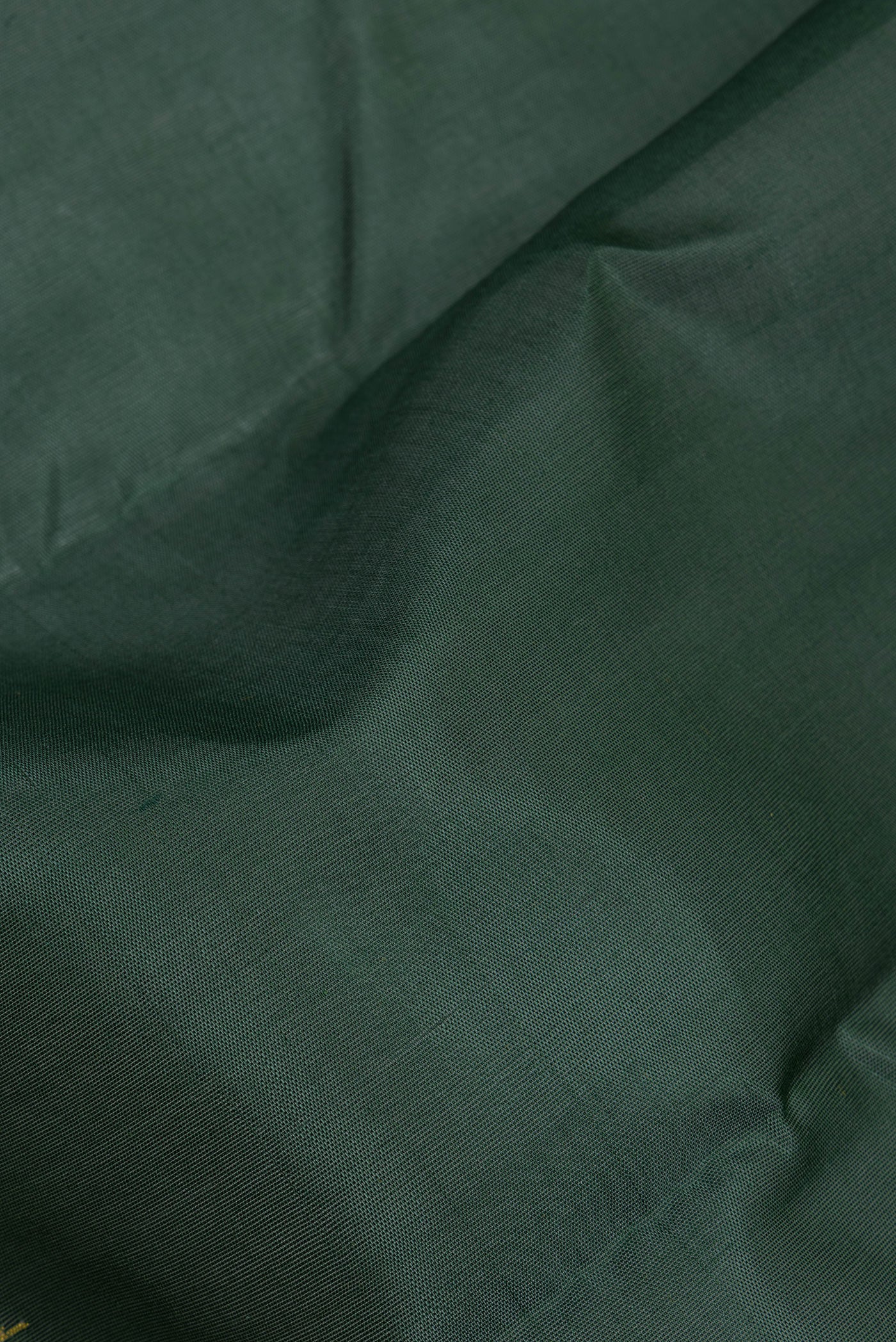 Close up of Bottle Green Kanchi Cotton Saree with Plain Body and Temple Border.  displaying folds