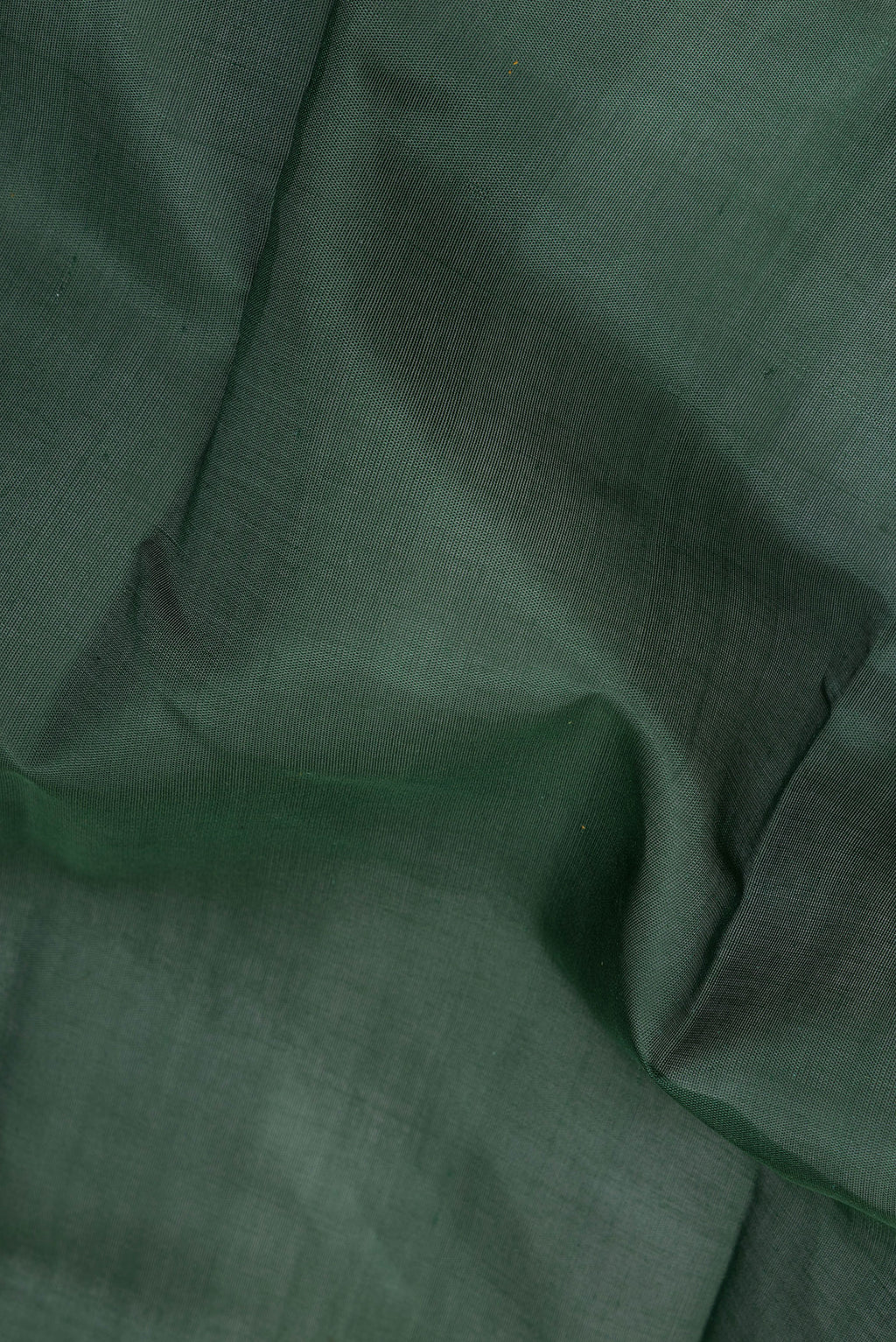 Close up of Bottle Green Kanchi Cotton Saree with Plain Body and Temple Border.  displaying folds