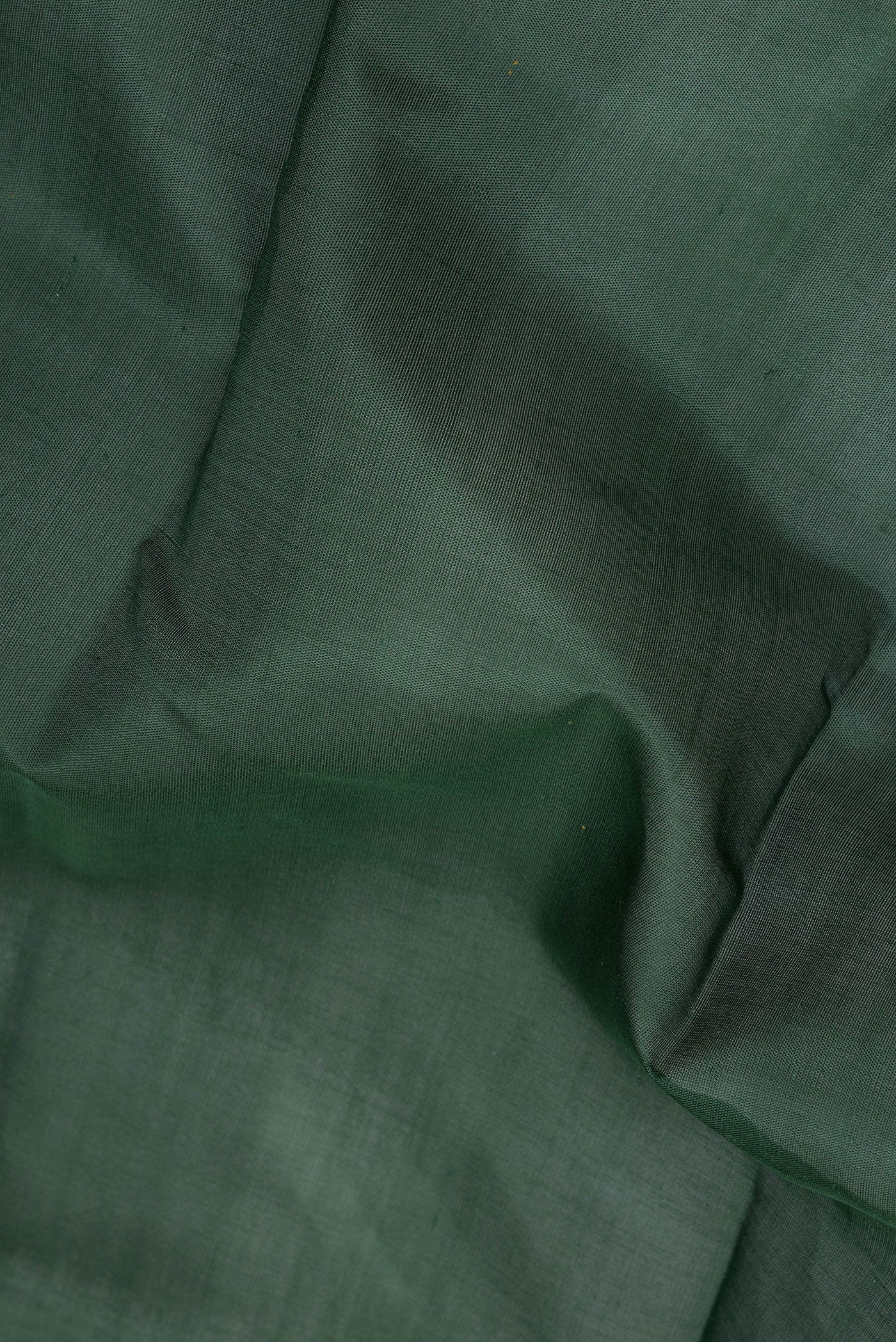 Close up of Bottle Green Kanchi Cotton Saree with Plain Body and Temple Border.  displaying folds