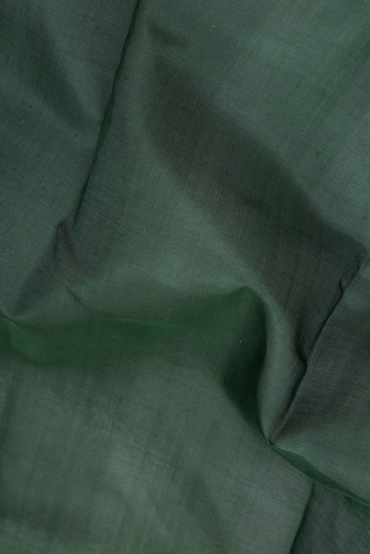 Close up of Bottle Green Kanchi Cotton Saree with Plain Body and Temple Border.  displaying folds