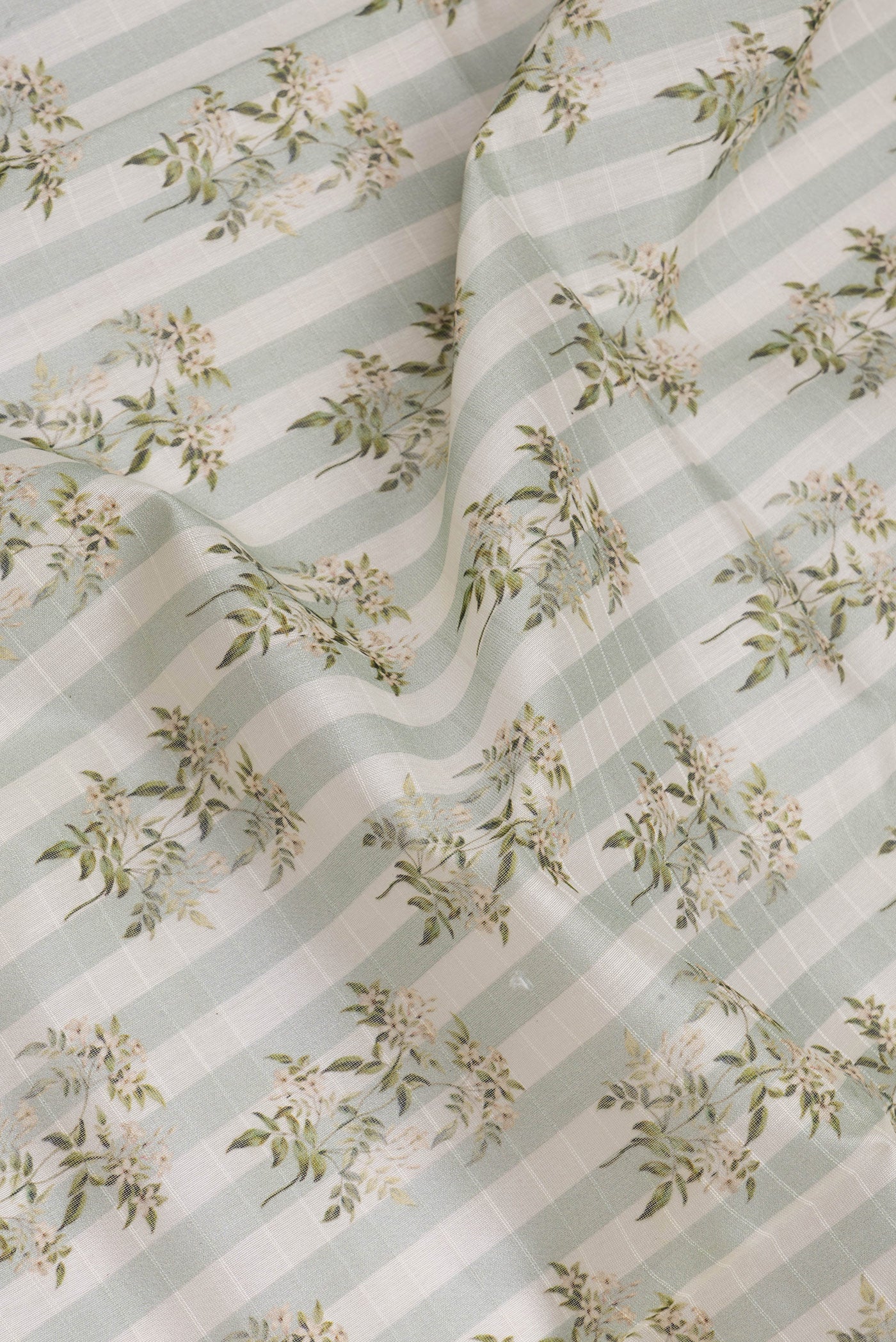 Close up of Green Dual Tone Chanderi Silk Saree with Printed design on the body and Zari And Thread Border.  displaying folds
