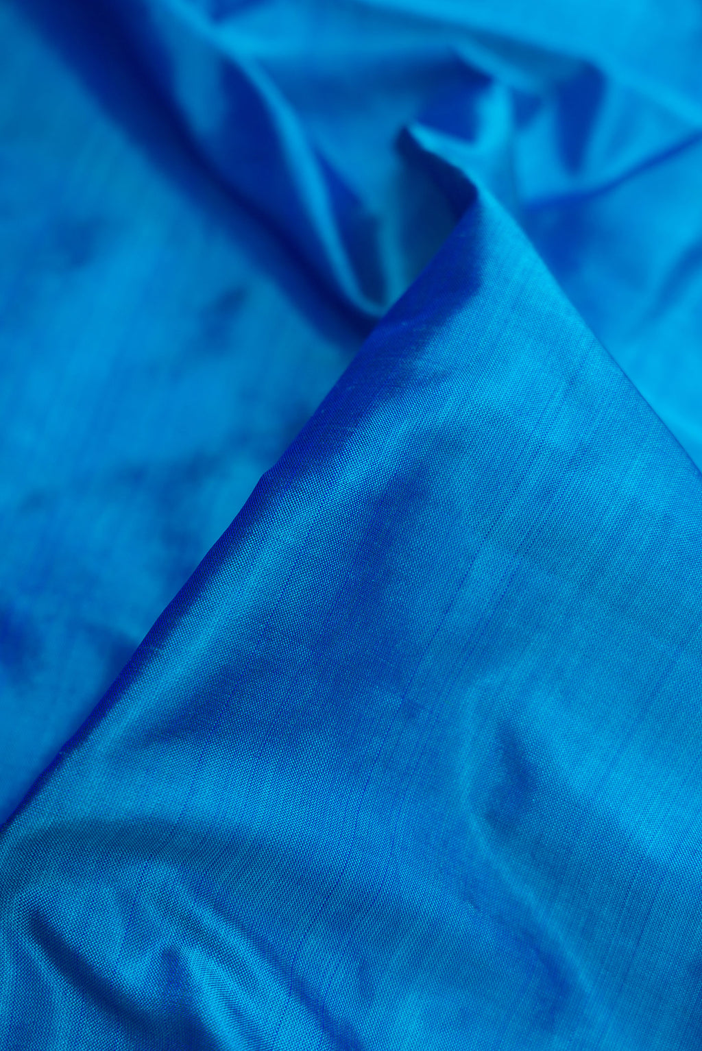 Close up of Peacock Blue Dual Tone Kanjivaram Silk Nine Yards Saree with Plain Body and Zari Border.  displaying folds