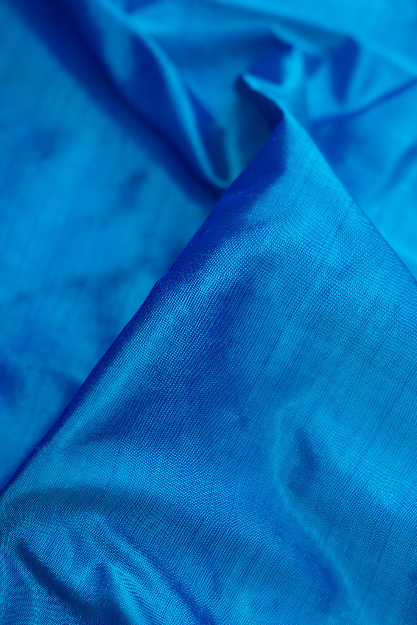 Close up of Peacock Blue Dual Tone Kanjivaram Silk Nine Yards Saree with Plain Body and Zari Border.  displaying folds