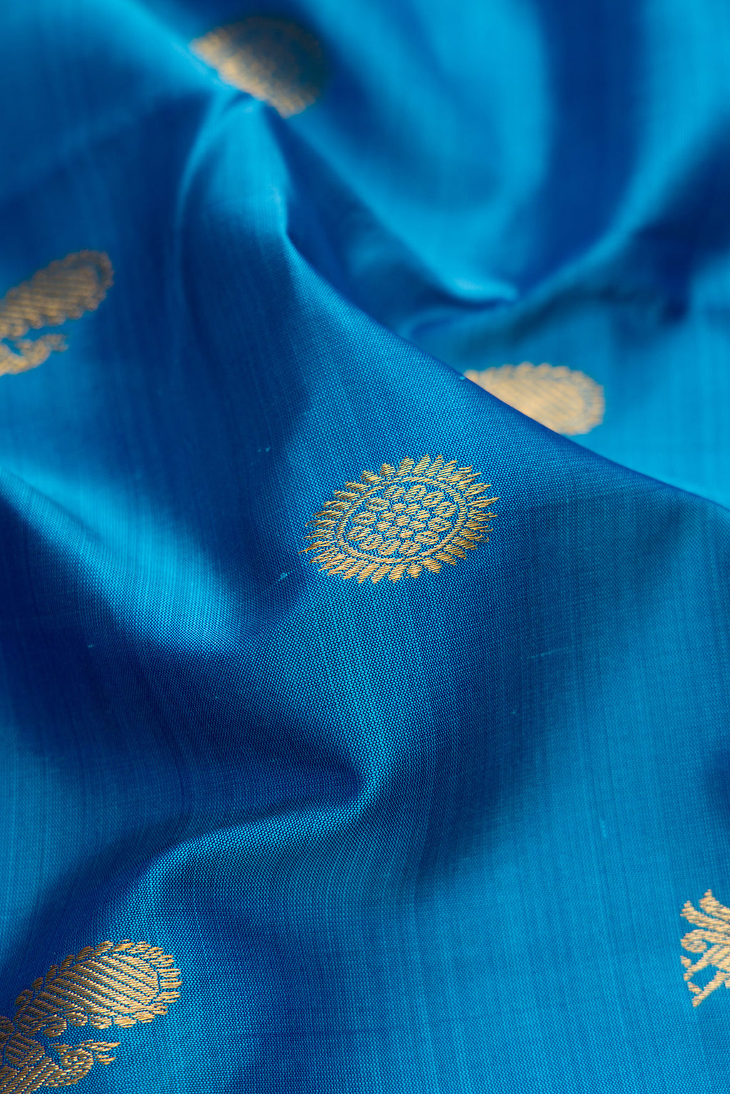 Close up of Pure Silk Pure Zari Peacock Blue Dual Tone Kanchipuram Nine Yards Saree with Zari Butta on the body and Zari Border.  displaying folds