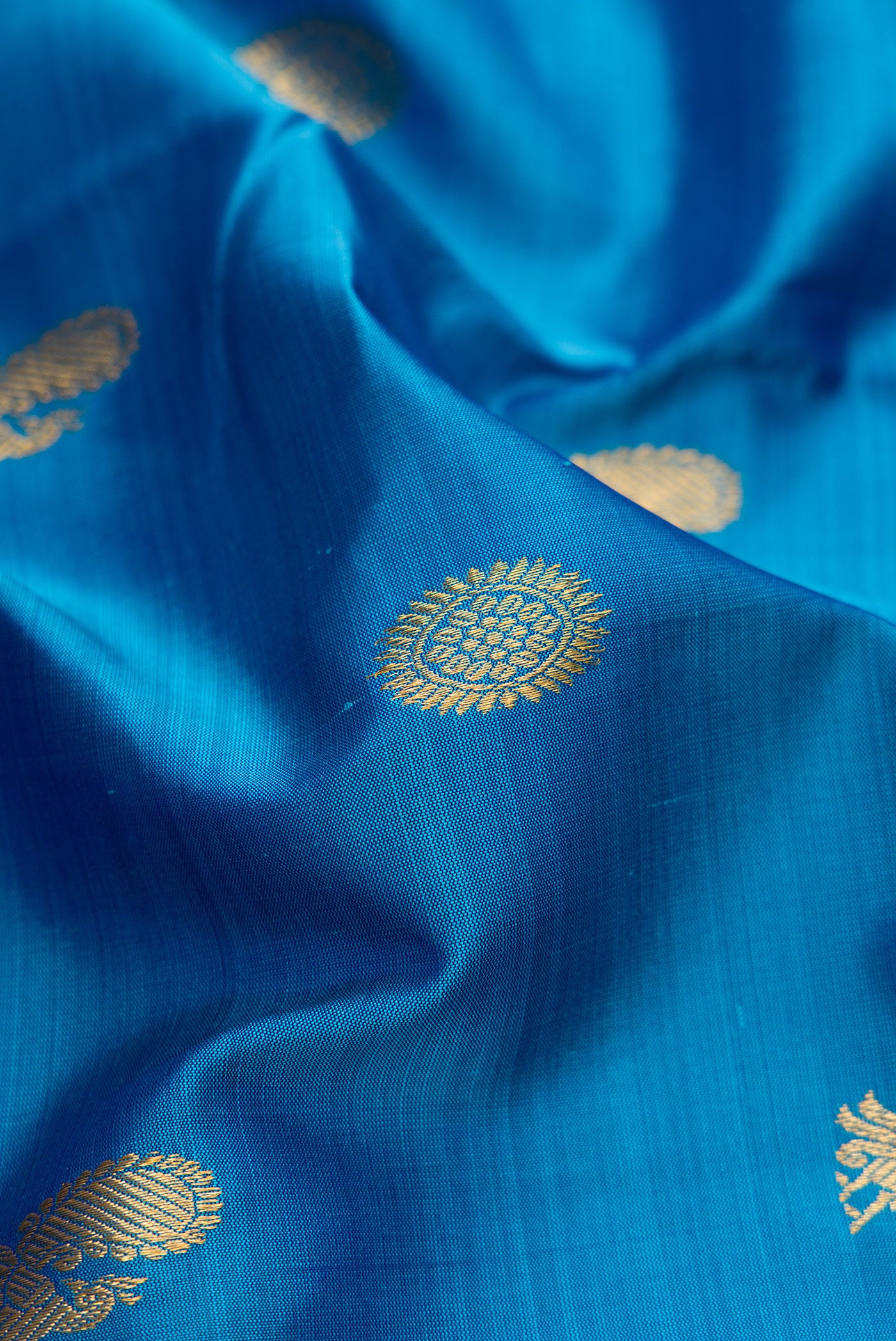 Close up of Pure Silk Pure Zari Peacock Blue Dual Tone Kanchipuram Nine Yards Saree with Zari Butta on the body and Zari Border.  displaying folds