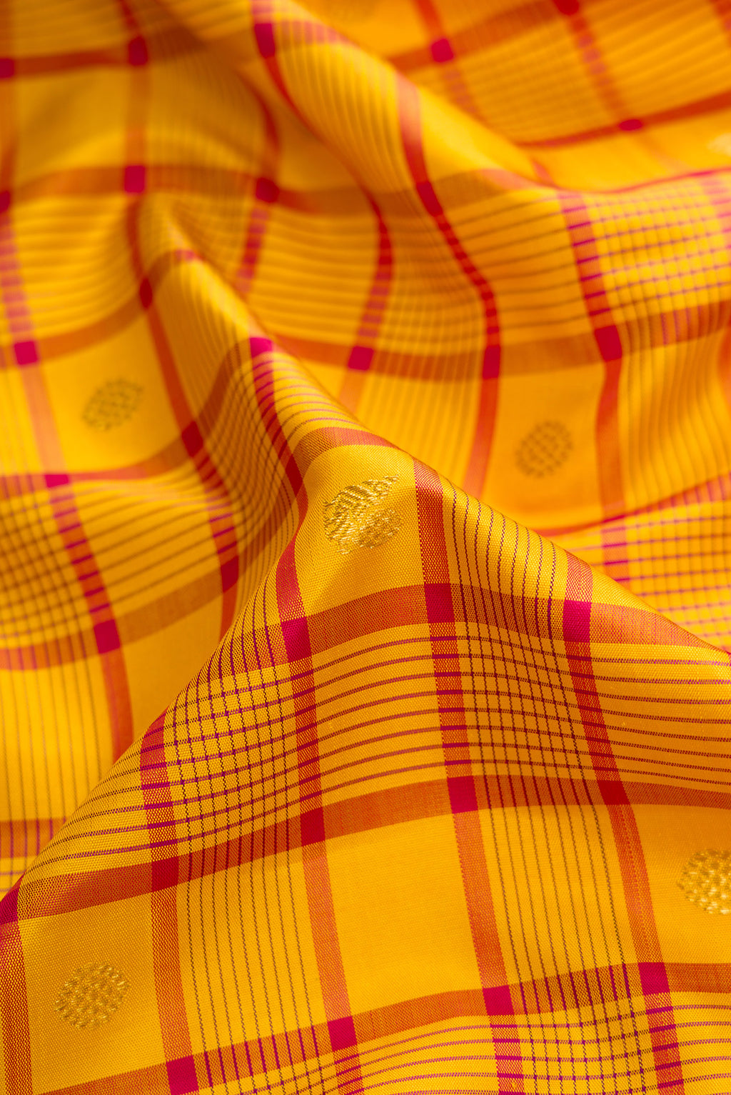 Close up of Pure Silk Pure Zari Mustard Dual Tone Kanjivaram Saree with Checked design on the body and Zari Border.  displaying folds