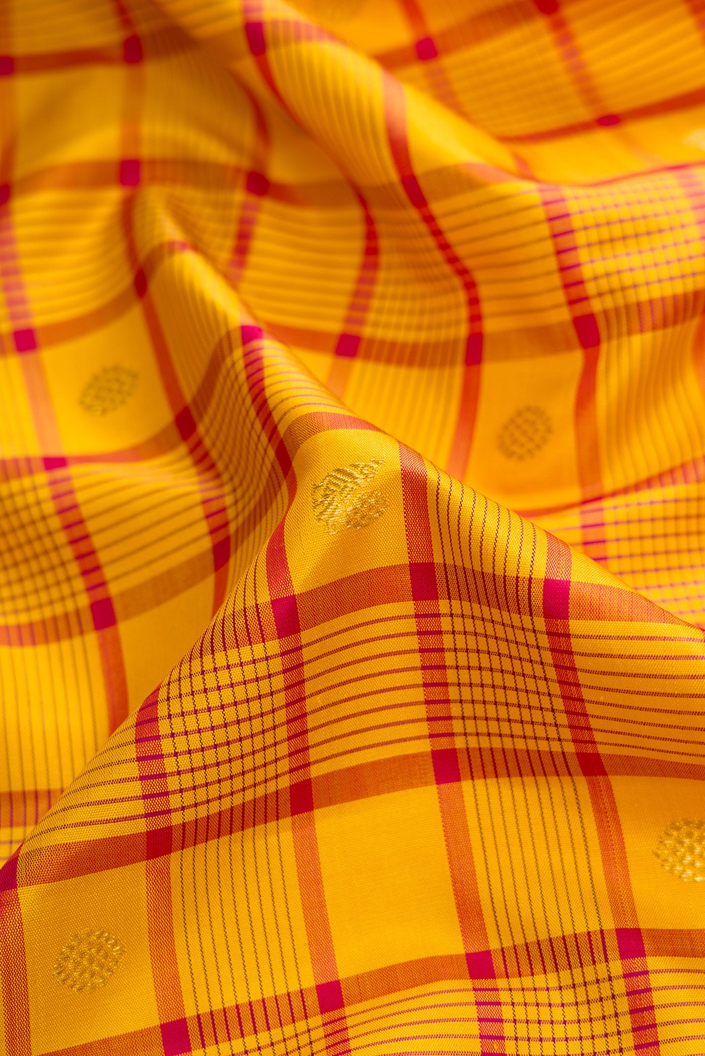 Close up of Pure Silk Pure Zari Mustard Dual Tone Kanjivaram Saree with Checked design on the body and Zari Border.  displaying folds