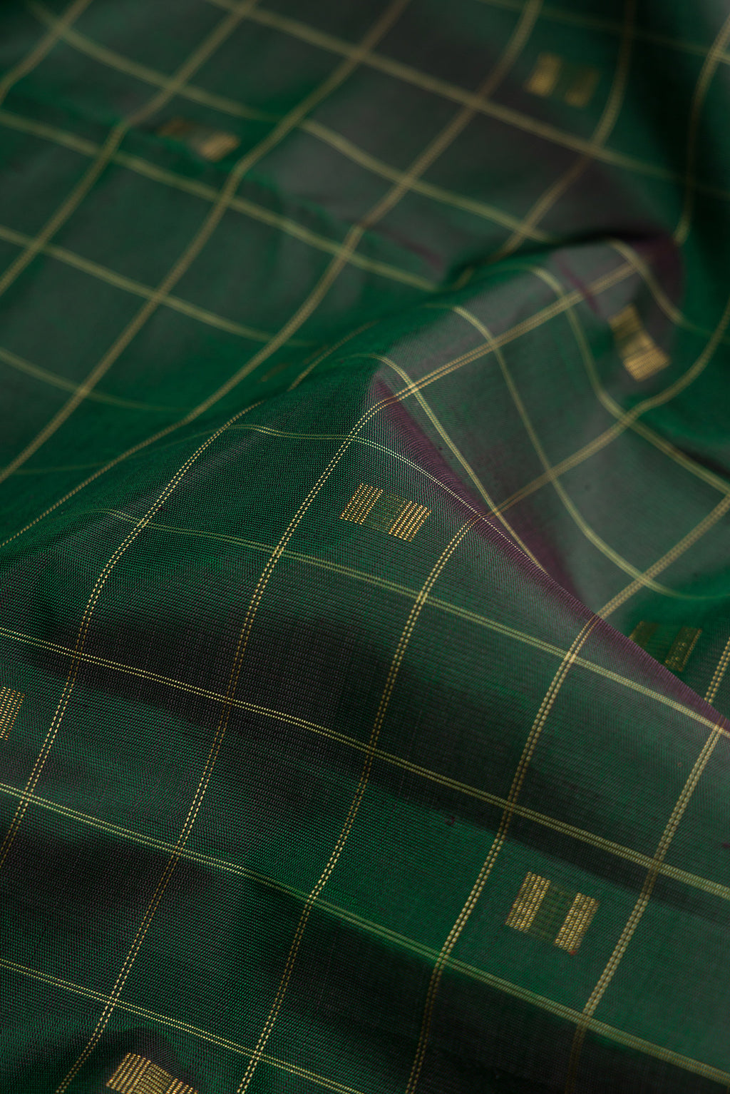 Close up of Pure Silk Pure Zari Green Dual Tone Kanjivaram Saree with Checked design on the body and Without Border.  displaying folds