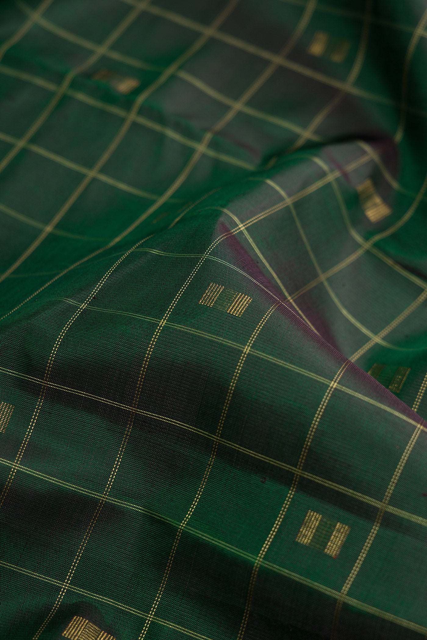 Close up of Pure Silk Pure Zari Green Dual Tone Kanjivaram Saree with Checked design on the body and Without Border.  displaying folds