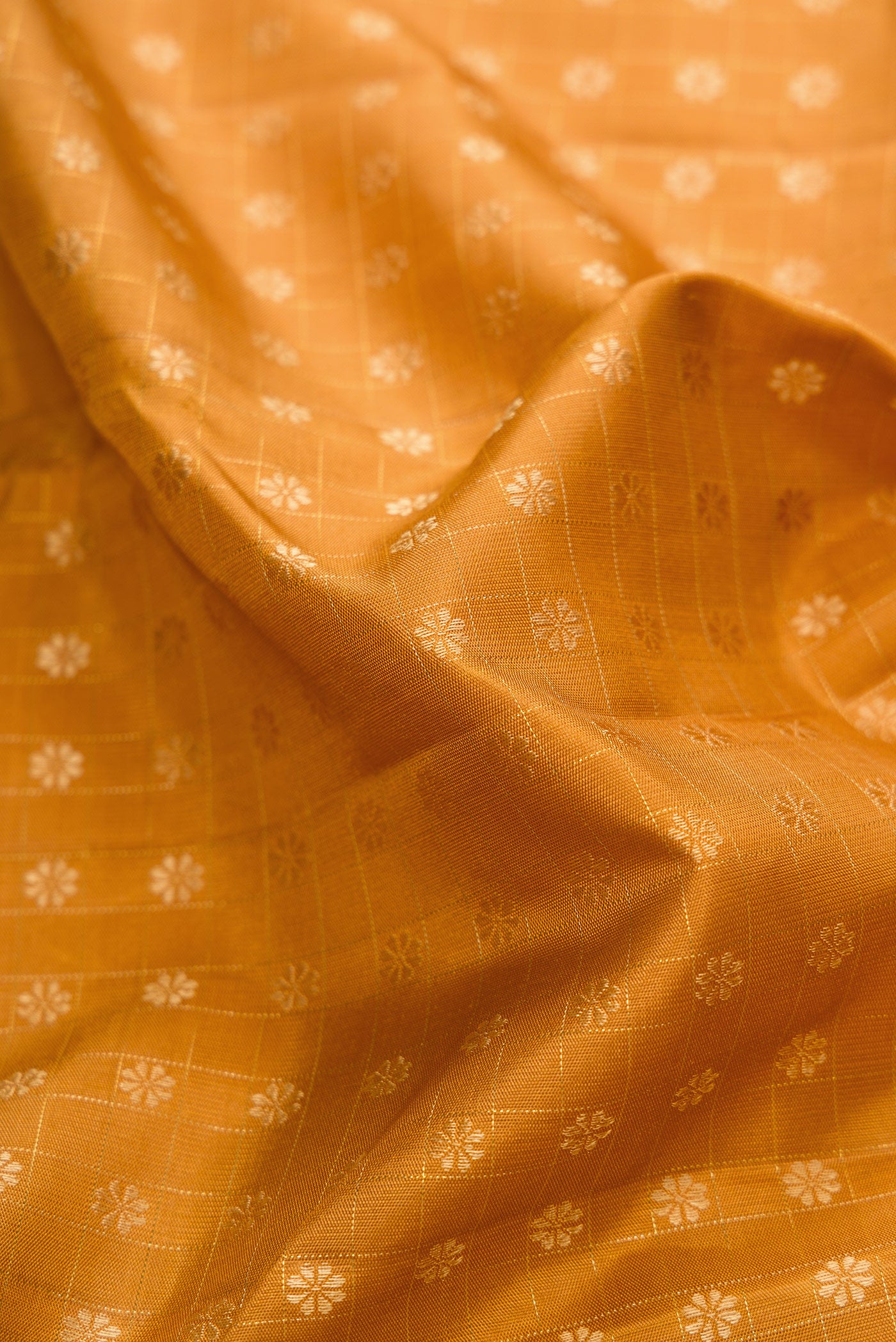 Close up of Mustard Dual Tone Kanchipuram Silk Saree with Zari Butta on the body and Zari Border.  displaying folds