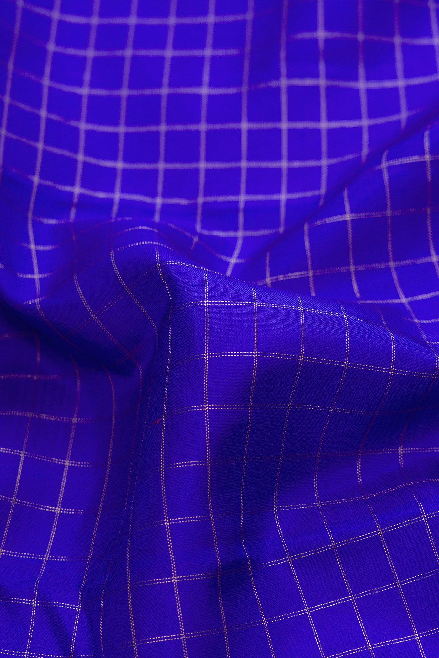 Close up of Pure Silk Pure Zari Royal Blue Dual Tone Kanchipuram Saree with Checked design on the body and Without Border.  displaying folds