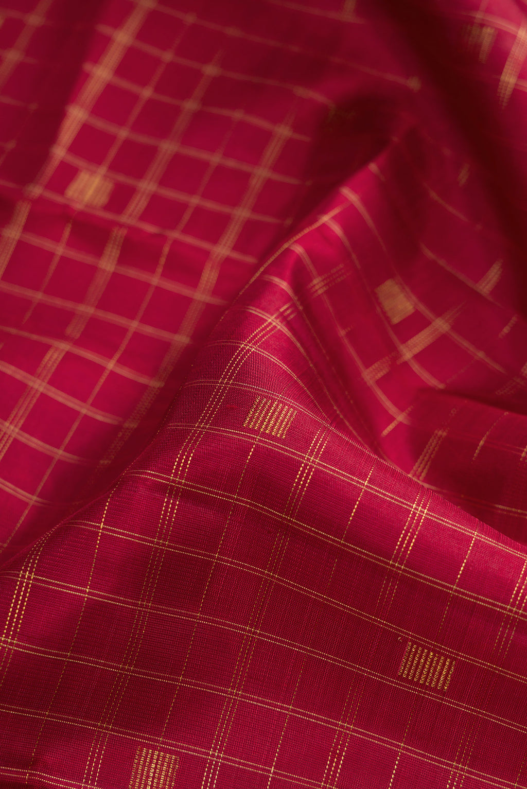 Close up of Pure Silk Pure Zari Maroon Dual Tone Kanchipuram Saree with Checked design on the body and Without Border.  displaying folds
