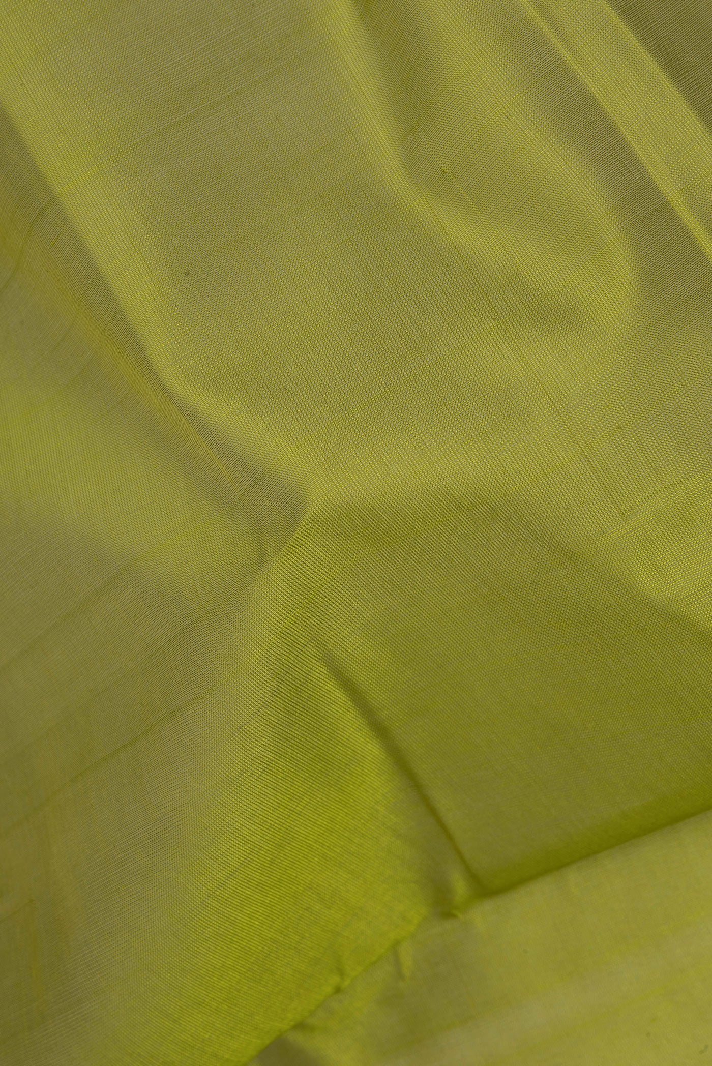 Close up of Green Silk Cotton Saree with Plain Body and Zari Border.  displaying folds